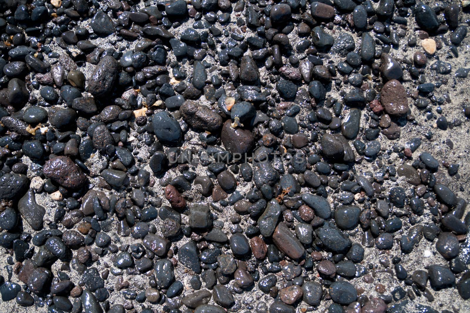 Volcanic black stones on the beach by tanaonte