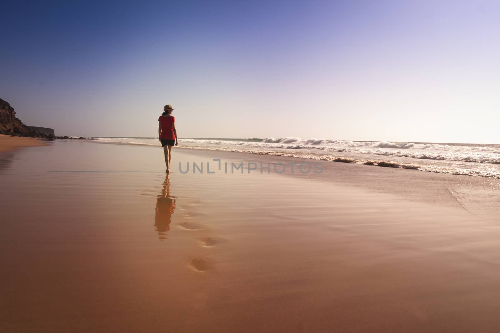 Solitary girl on beach looking at the sea by tanaonte