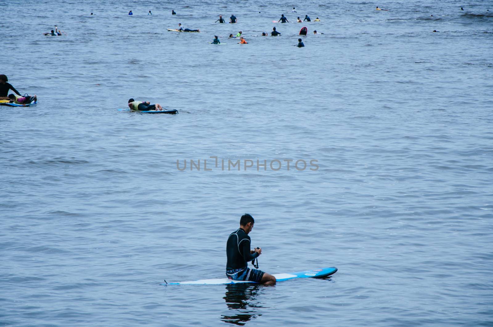 Surfer resting on his board in the sea
