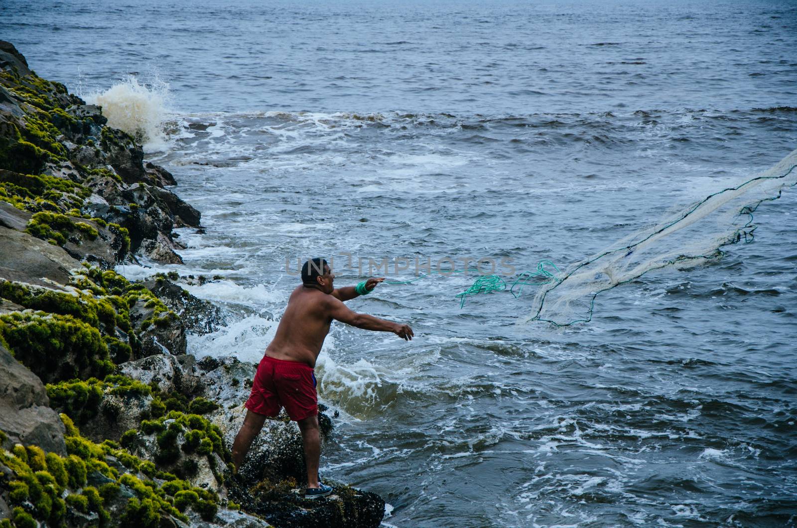 Fisherman throwing his net to catch some fish