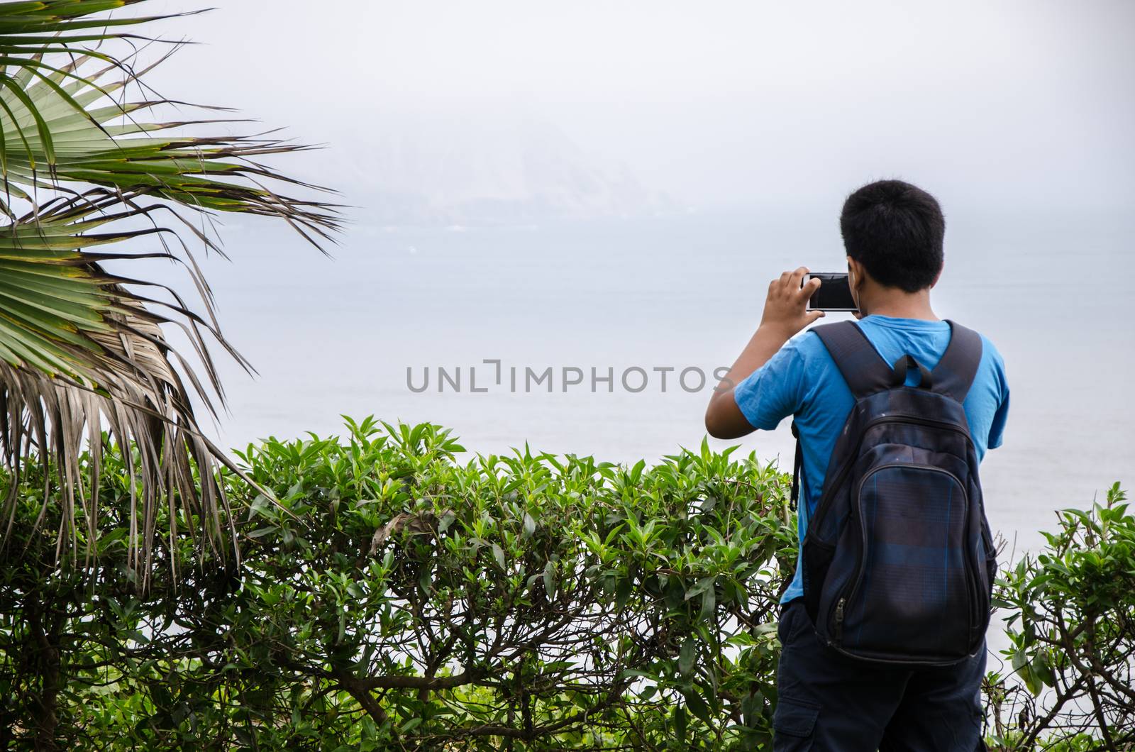 Child taking photo with his smartphone to the sea