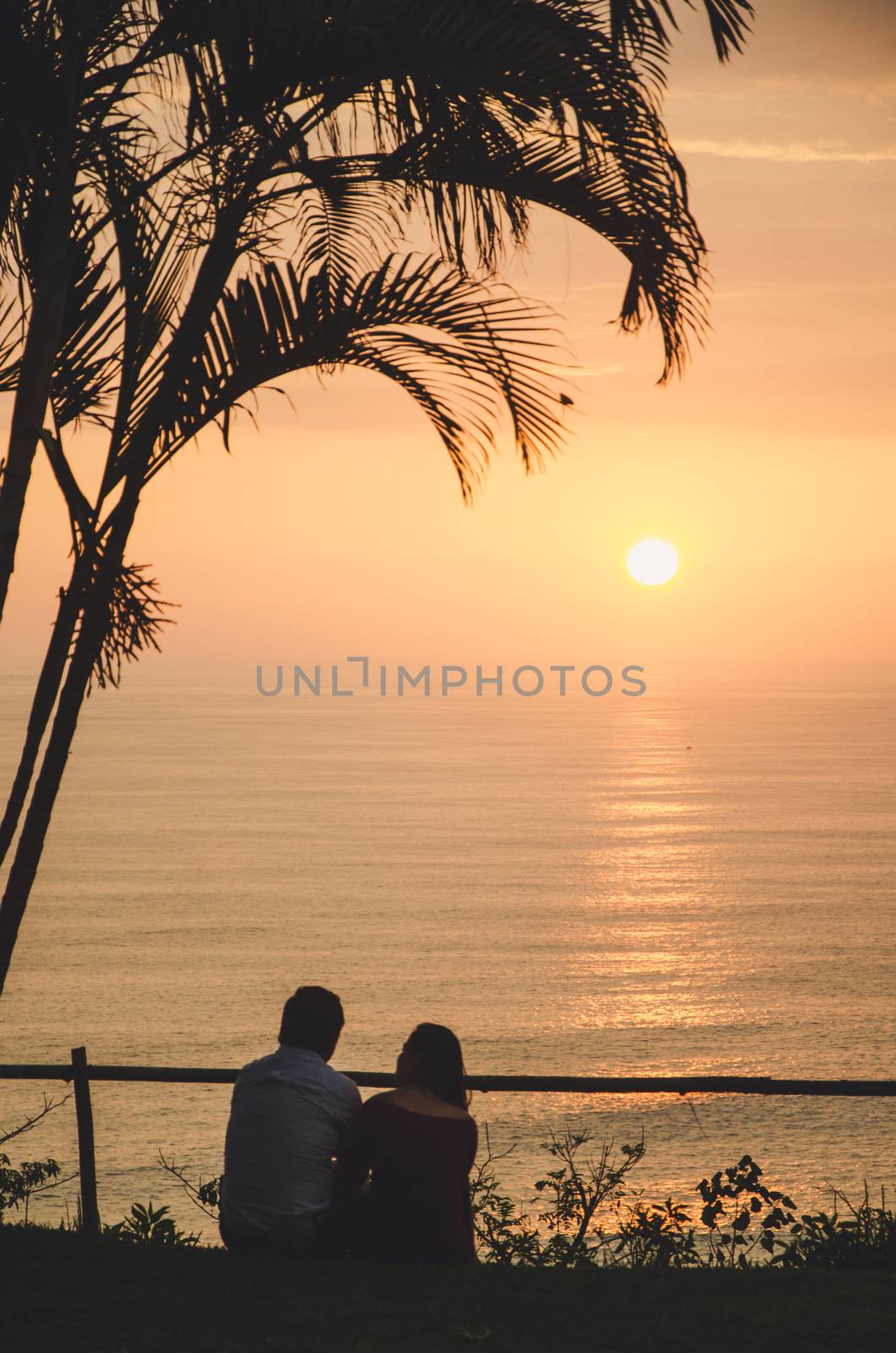 A couple in love sitting in front of the sea