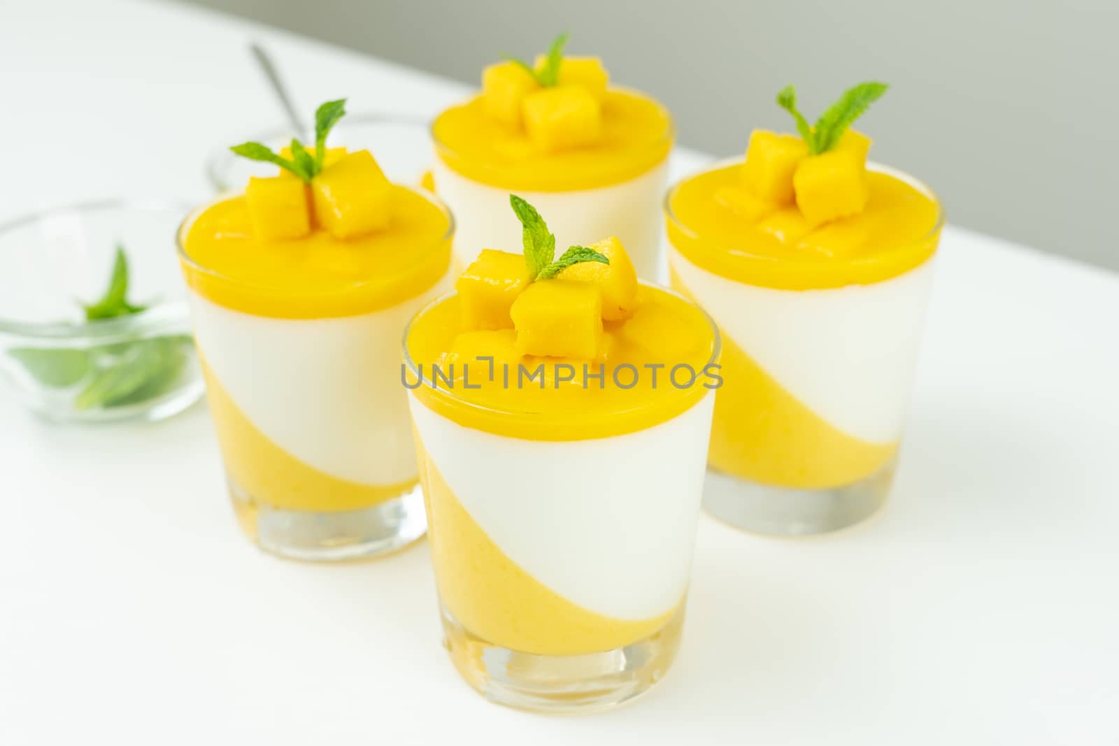 Italian dessert mango panna cotta decorated with fresh mango and mint