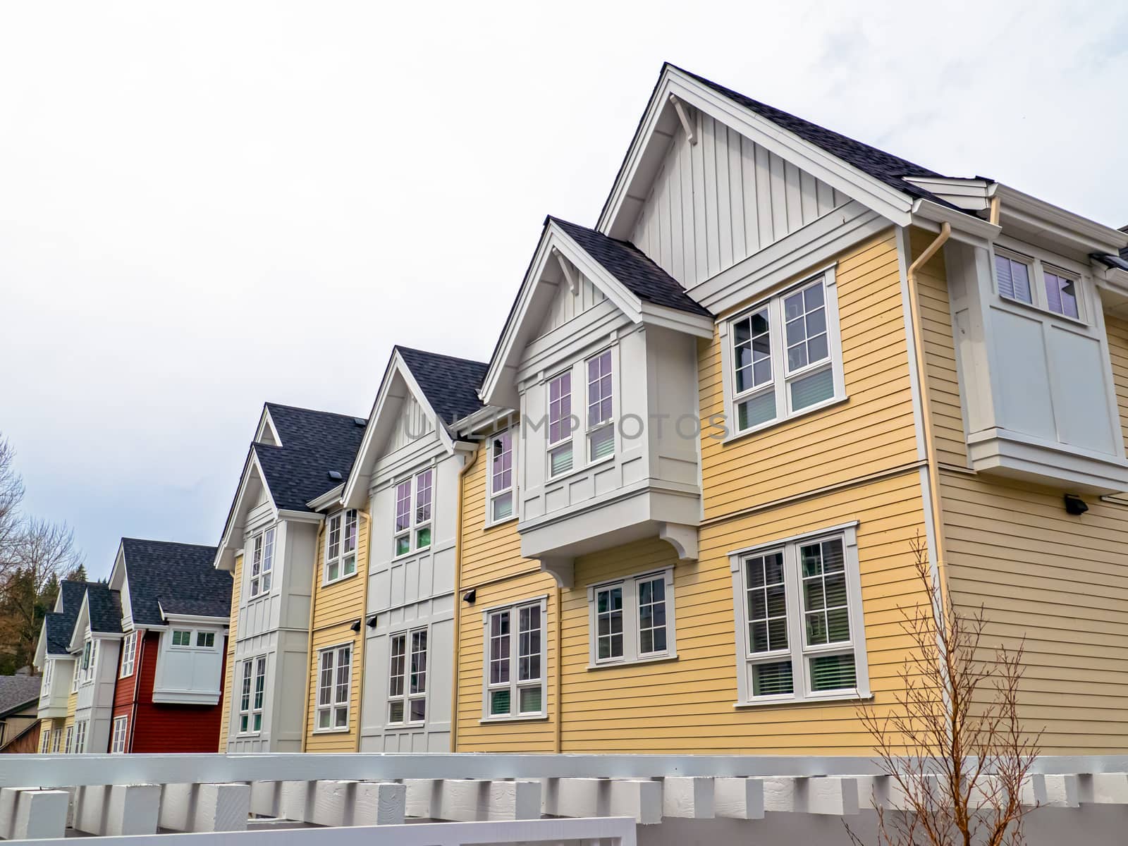 Top levels of residential townhouses on overcast sky backgfound.