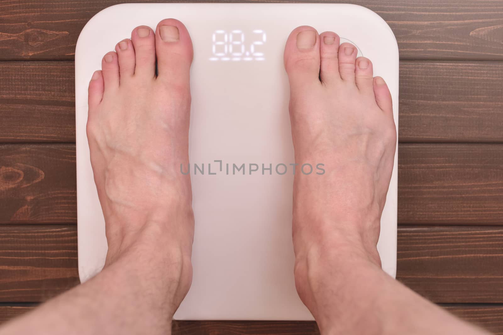 men's feet on an modern electronic scales. sports concept