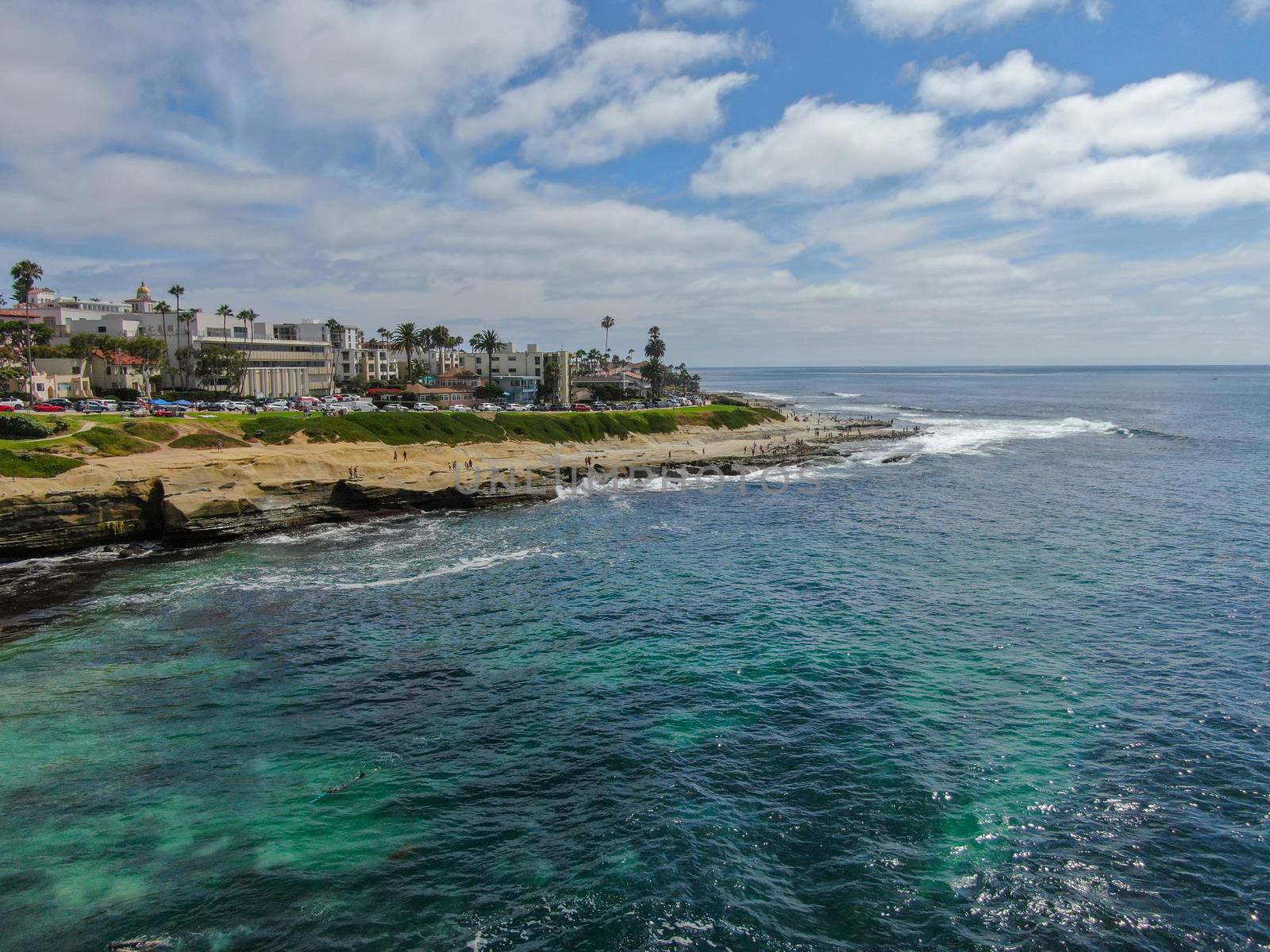 Aerial view of La Jolla coast, San Diego, California. Beach and blue sea with small waves. Hilly seaside of curving coastline along the Pacific.