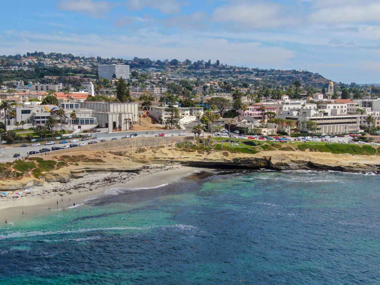 Aerial view of La Jolla coast, San Diego, California. Beach and blue sea with small waves. Hilly seaside of curving coastline along the Pacific.