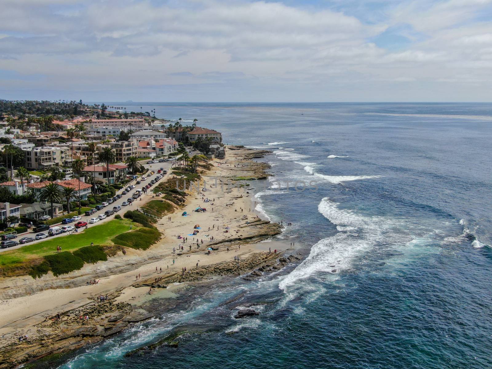 Aerial view of La Jolla coast, San Diego, California. Beach and blue sea with small waves. Hilly seaside of curving coastline along the Pacific.