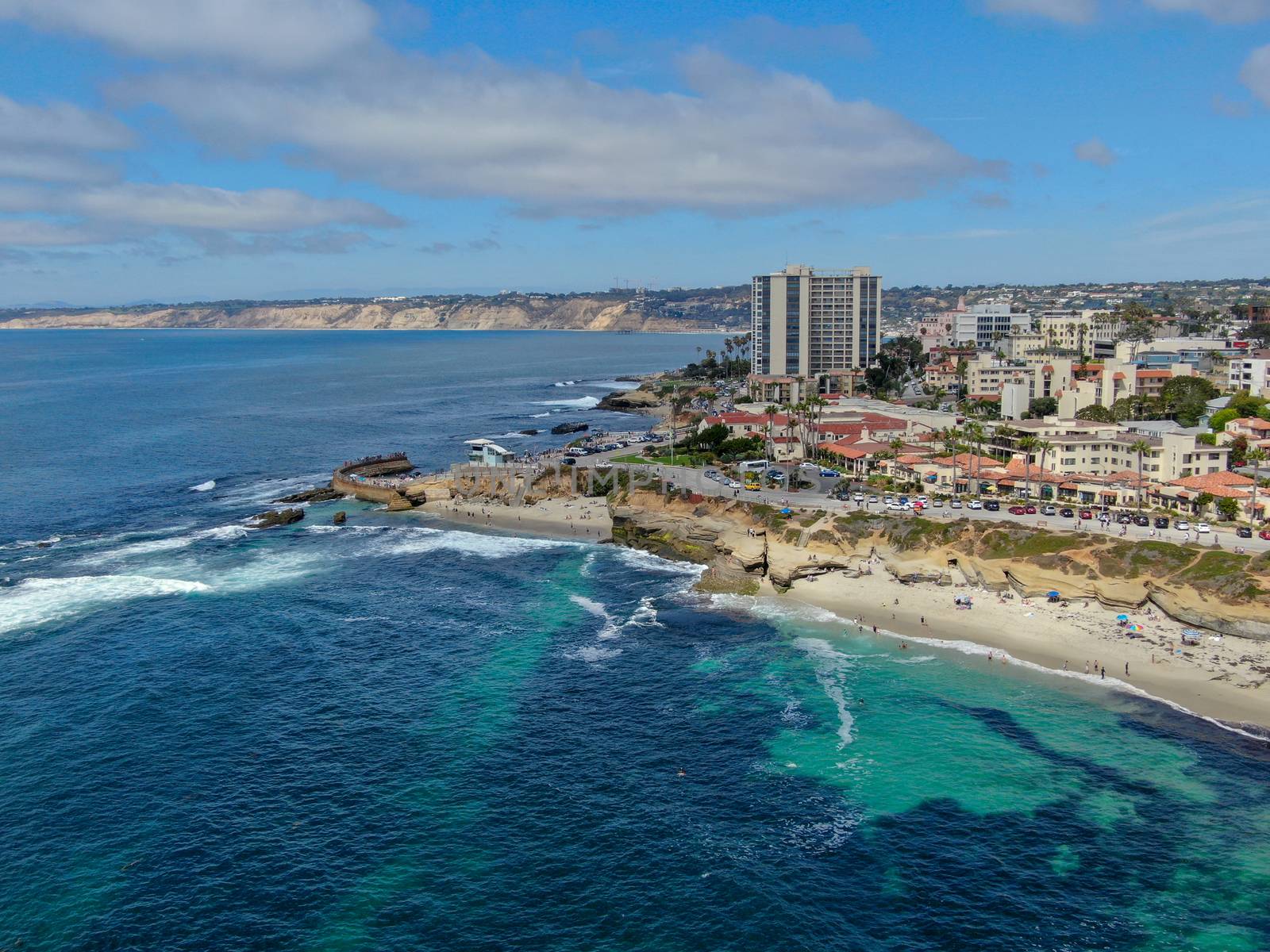 Aerial view of La Jolla coast, San Diego, California. Beach and blue sea with small waves. Hilly seaside of curving coastline along the Pacific.