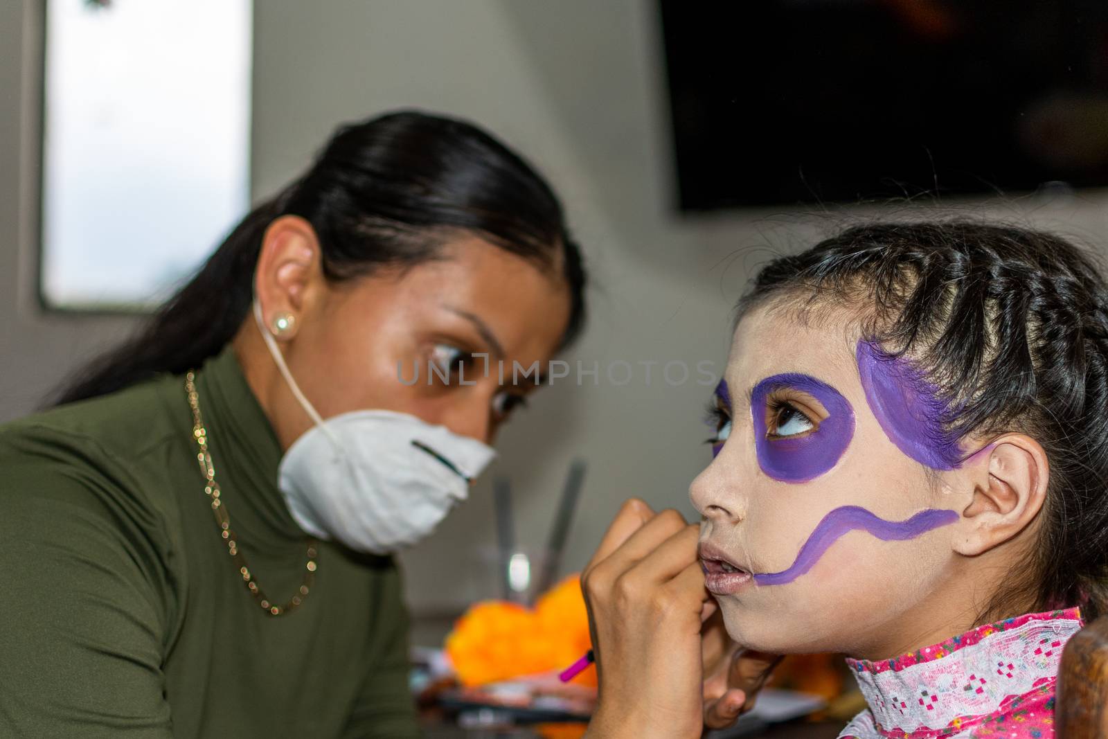 Young woman putting makeup of Catrina in a girl's face by Tonhio