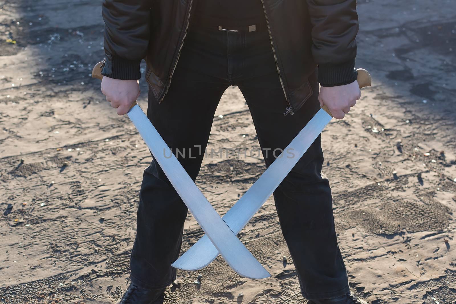 The man in the leather jacket, holding a crossed machete