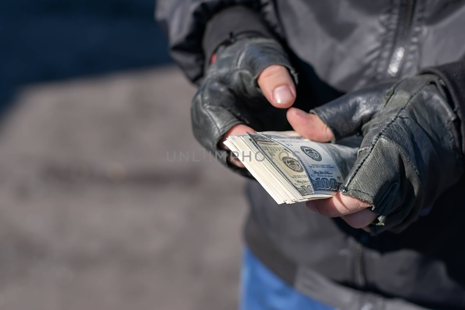 money in the hands of a bandit, a robber who counts the loot by jk3030