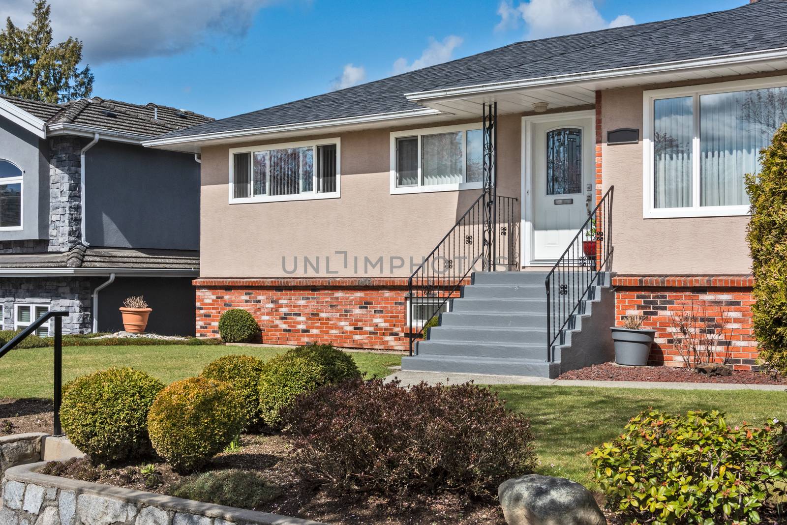 Average single family house with front yard on land terrace.