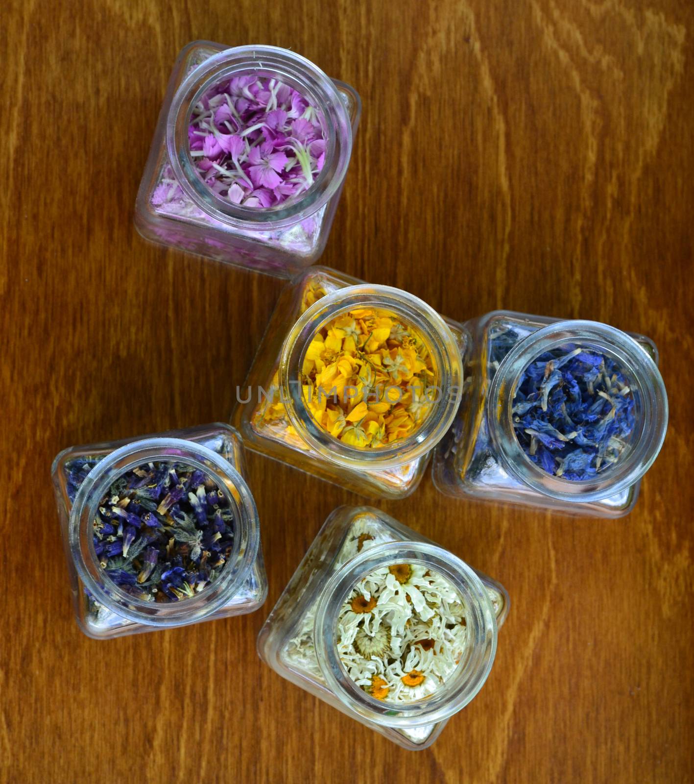 Set of small transparent jars with colored flowers