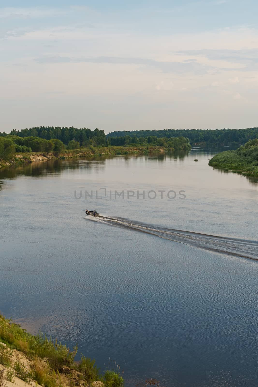 riverbank and a motor boat goes on the water by VADIM