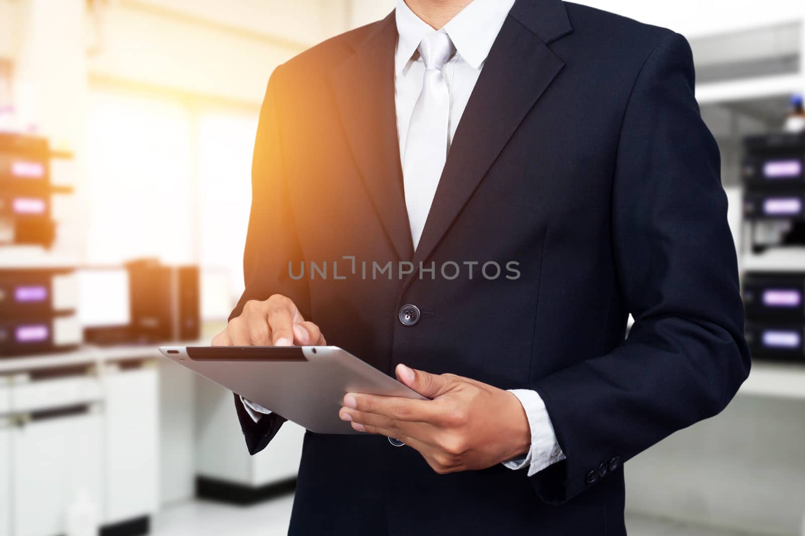 Business people with tablet ,digital technology concept. Young Asian business man working on digital tablet while standing in office background. light effect