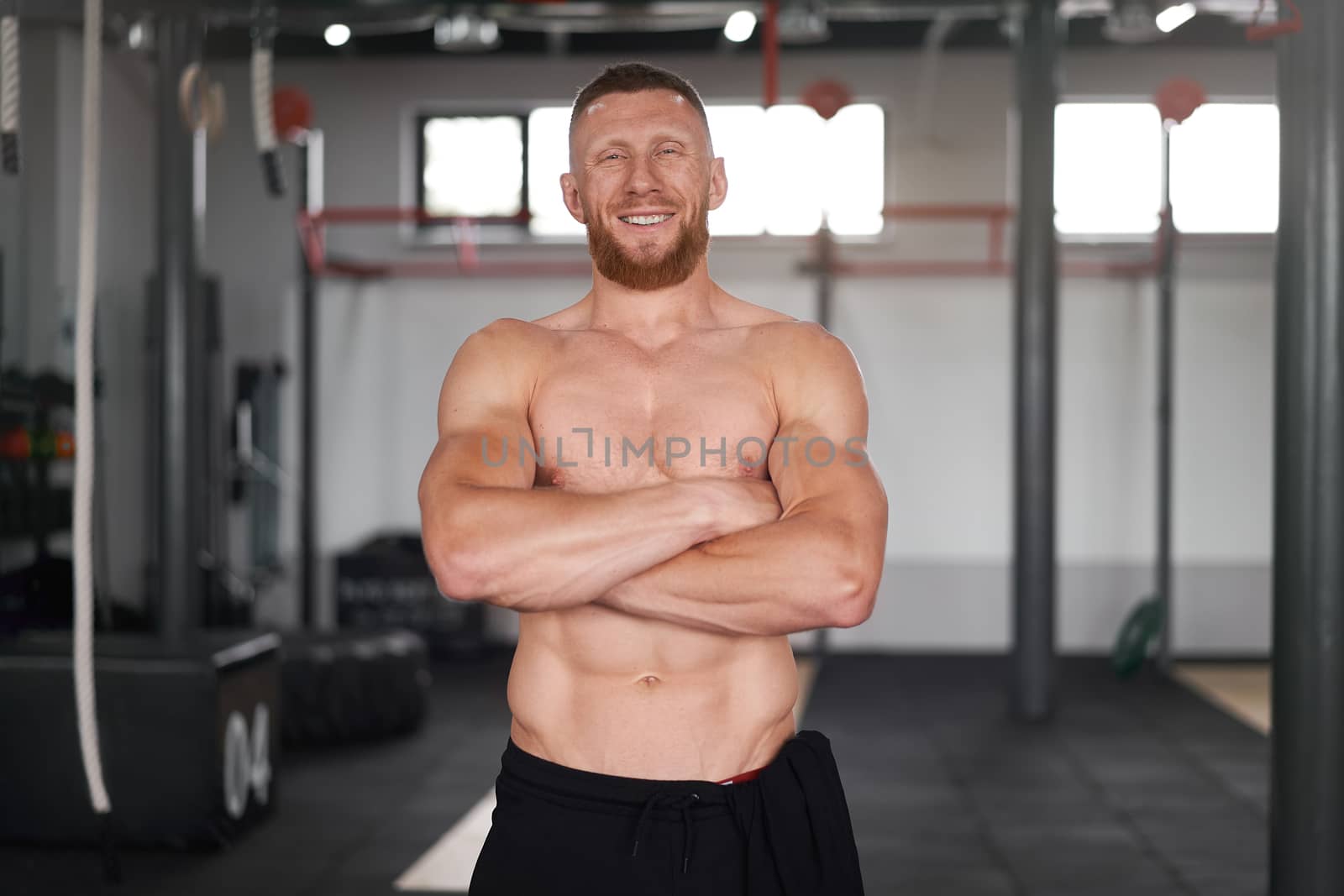 Athlete sportive man gym Middle adult handsome sportsman bodybuilder weightlifter ideal body after training abs muscles biceps triceps Arms crossed trainer standing indoor naked torso