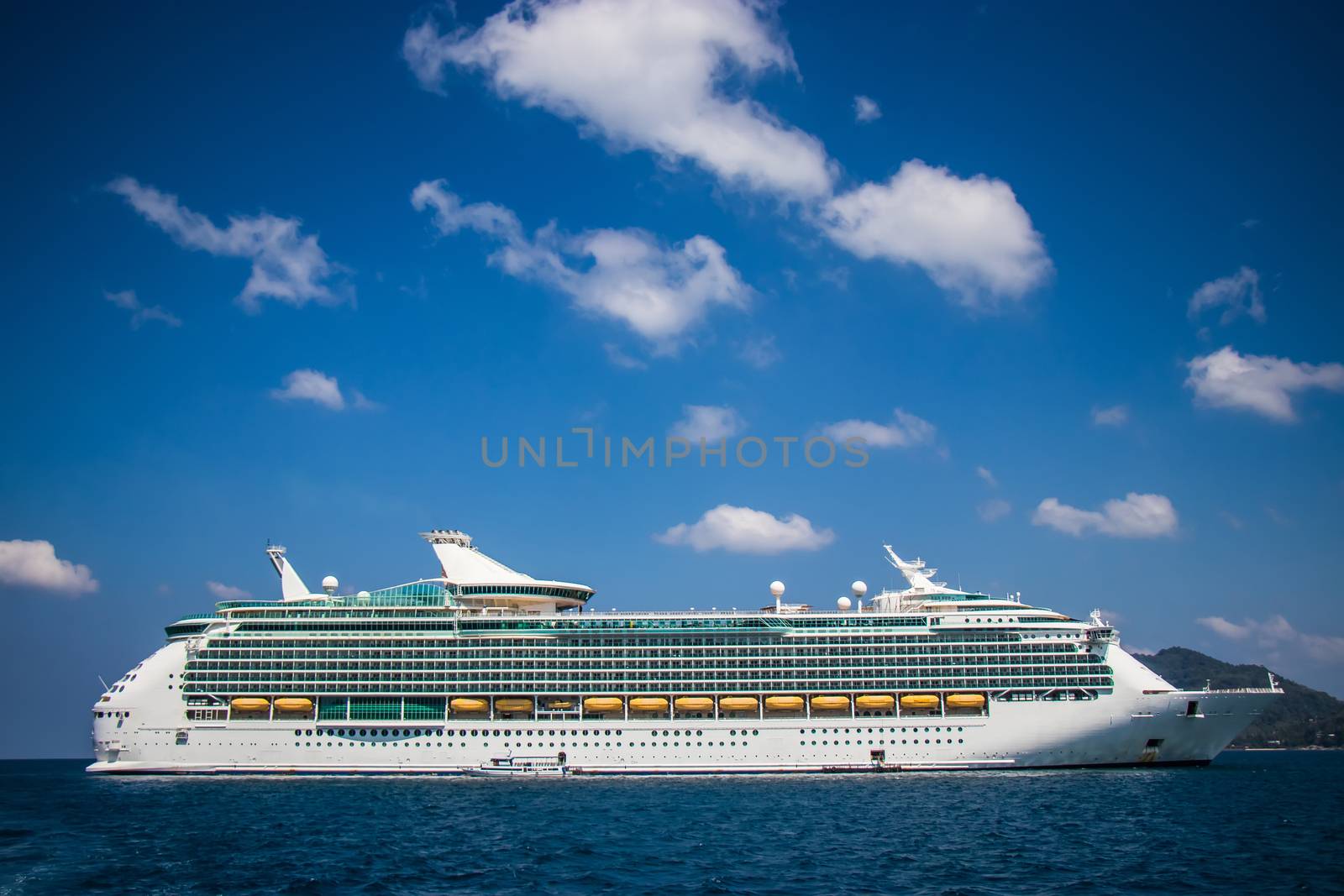 Luxury cruise ship sailing from port. Big cruise ship in the sea with beautiful blue sky background. Beautiful summer seascape poster for advertise. Holiday vacation lifestyle on cruise.