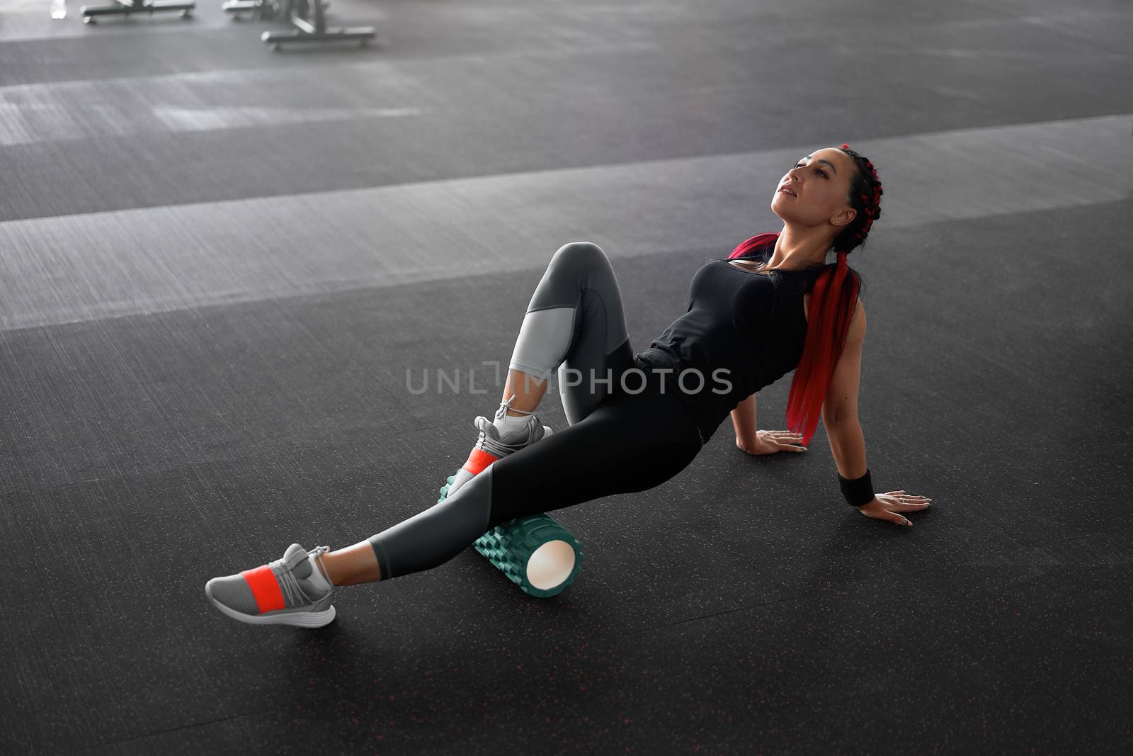 Woman massaging foam roll leg gym myofascial release exercise rolling, trigger points Middle adult caucasian woman sportswoman uses roller massager for relaxation, stretching muscles and back pain.