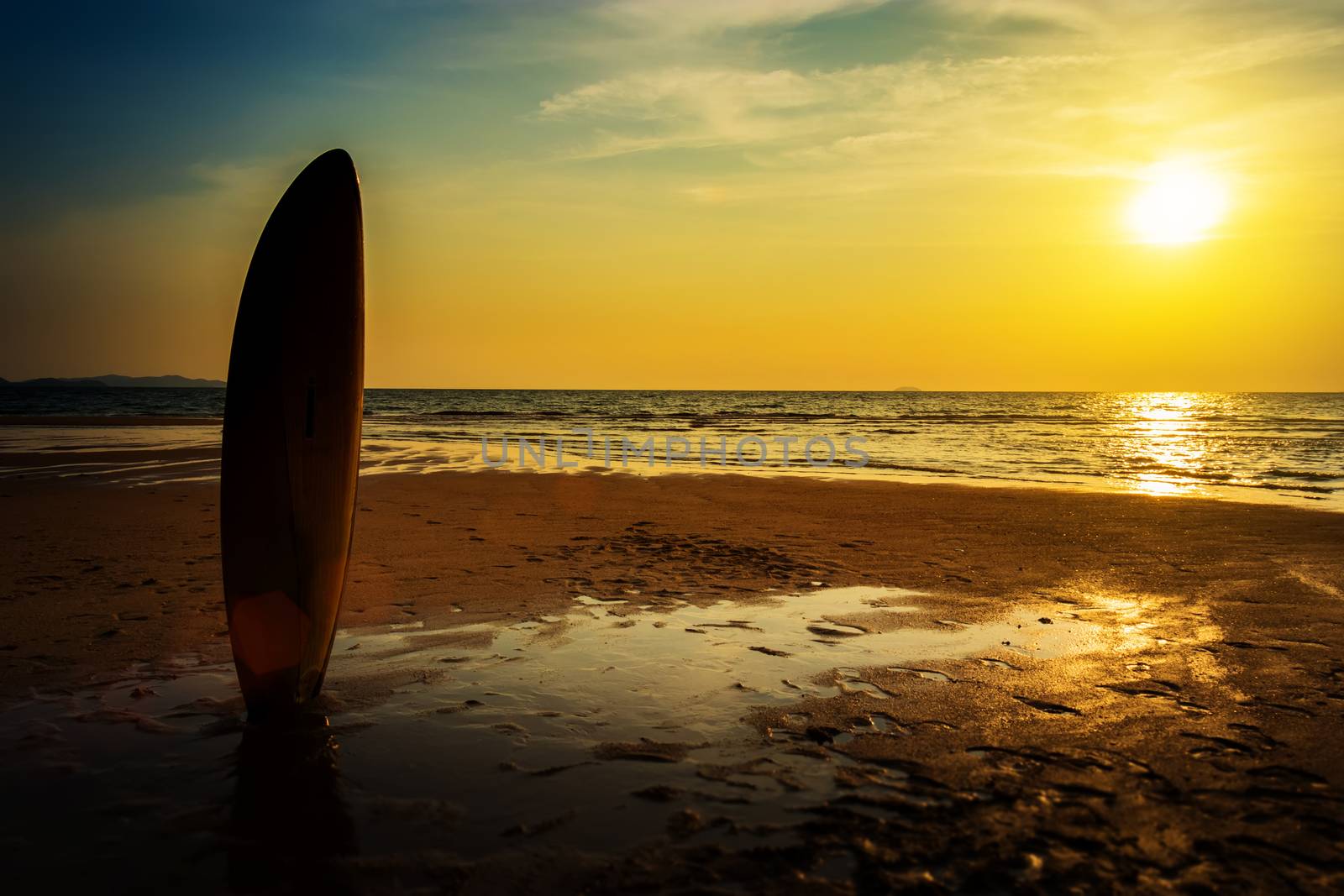 Surfing for water sport outdoor activity lifestyle concept. Silhouette of surfboard on the beach in sea shore at sunset time with beautiful light. water sport background