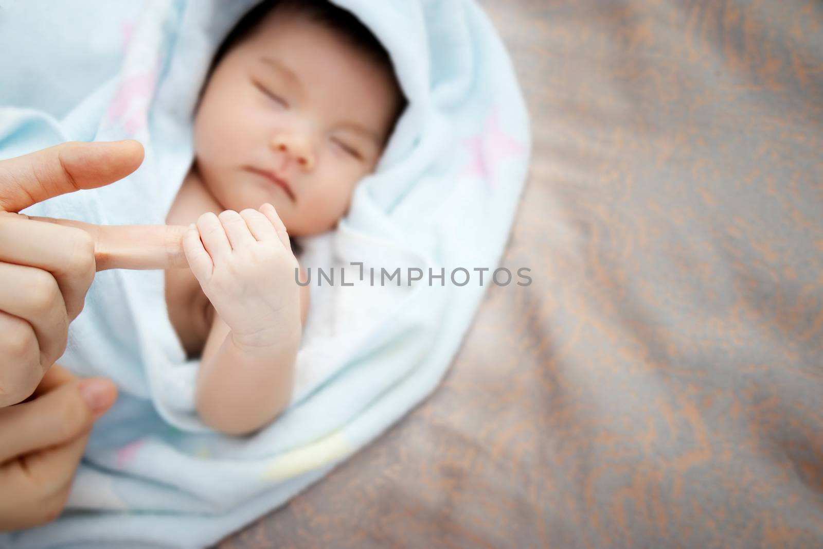 Concept of love and family relationship : close up newborn Asian baby hand hold round of mother finger with copy space at right side. Asia baby portrait . by asiandelight