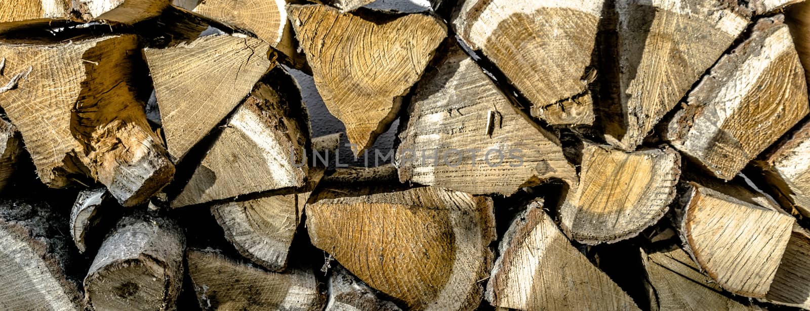 Close-up view of a stack of chopped wood for the fireplace fire in winter, background or wallpaper