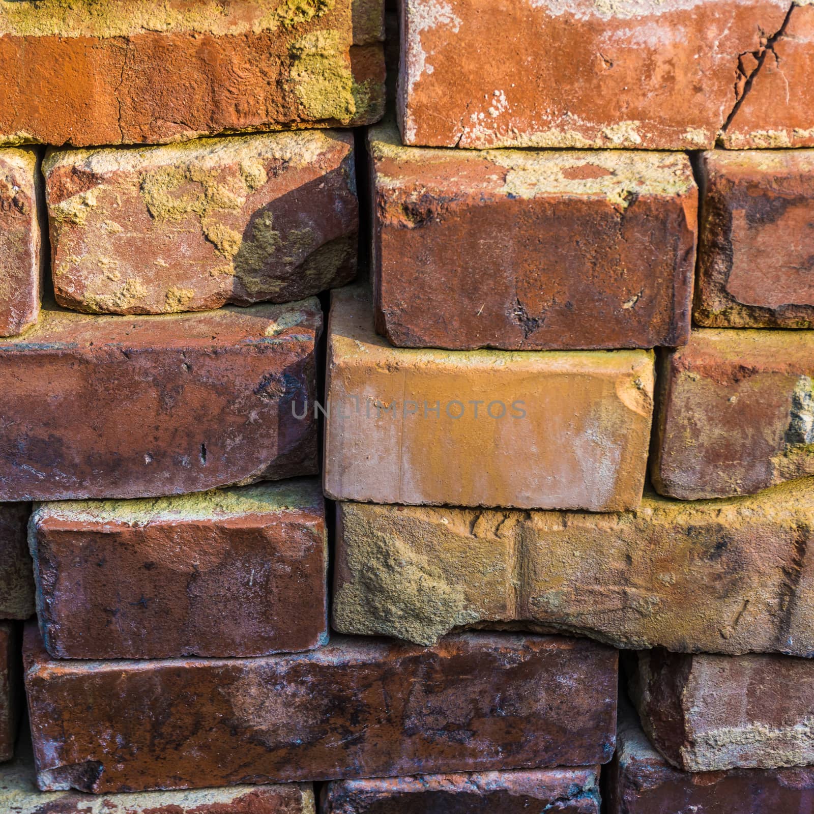 Old red bricks carefully stacked for later recycling, background or wallpaper