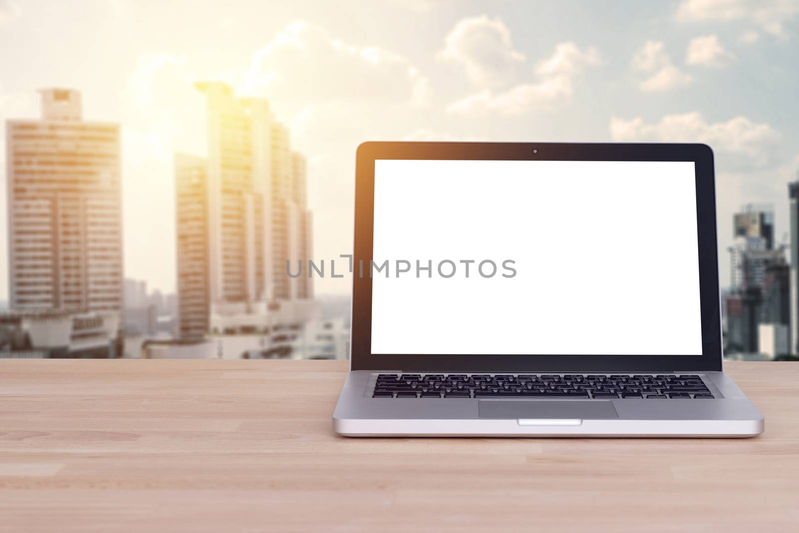 Technology for comfortable business concept : Blank white screen on notebook , laptop with blur building and cityscape background , film effect. by asiandelight