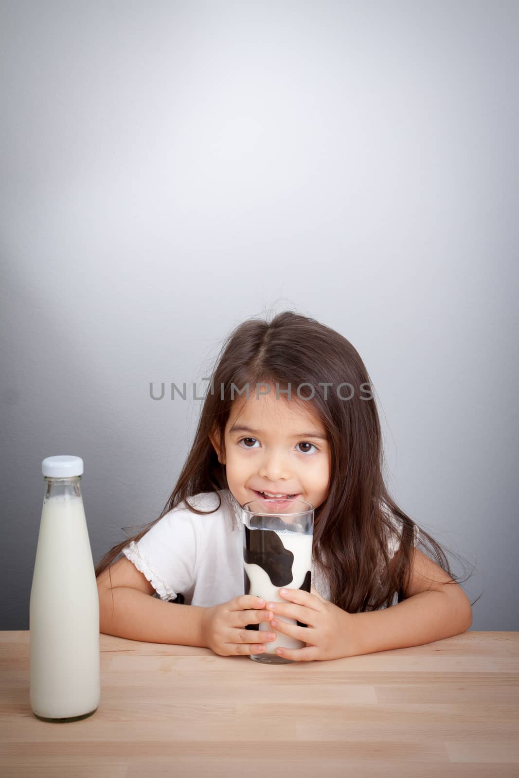 Adorable baby girl holding glass of milk and drinking milk by asiandelight