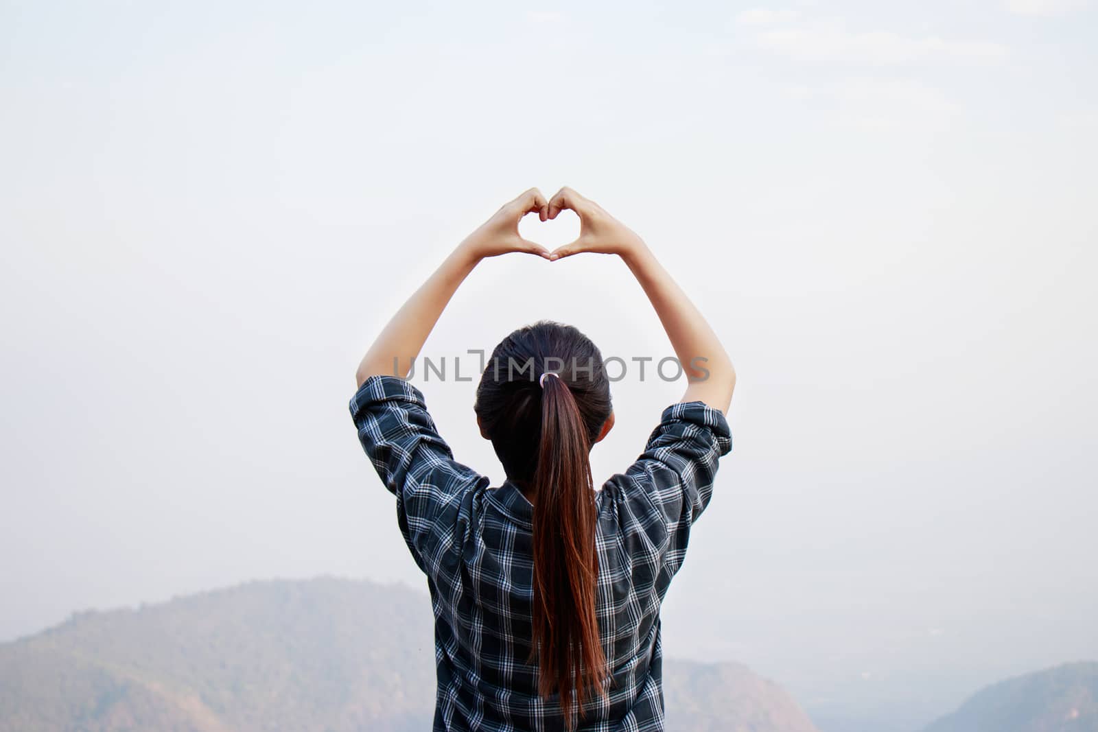 I love travel concept : Freedom traveler woman standing with heart shaped hands and enjoy a wonderful nature