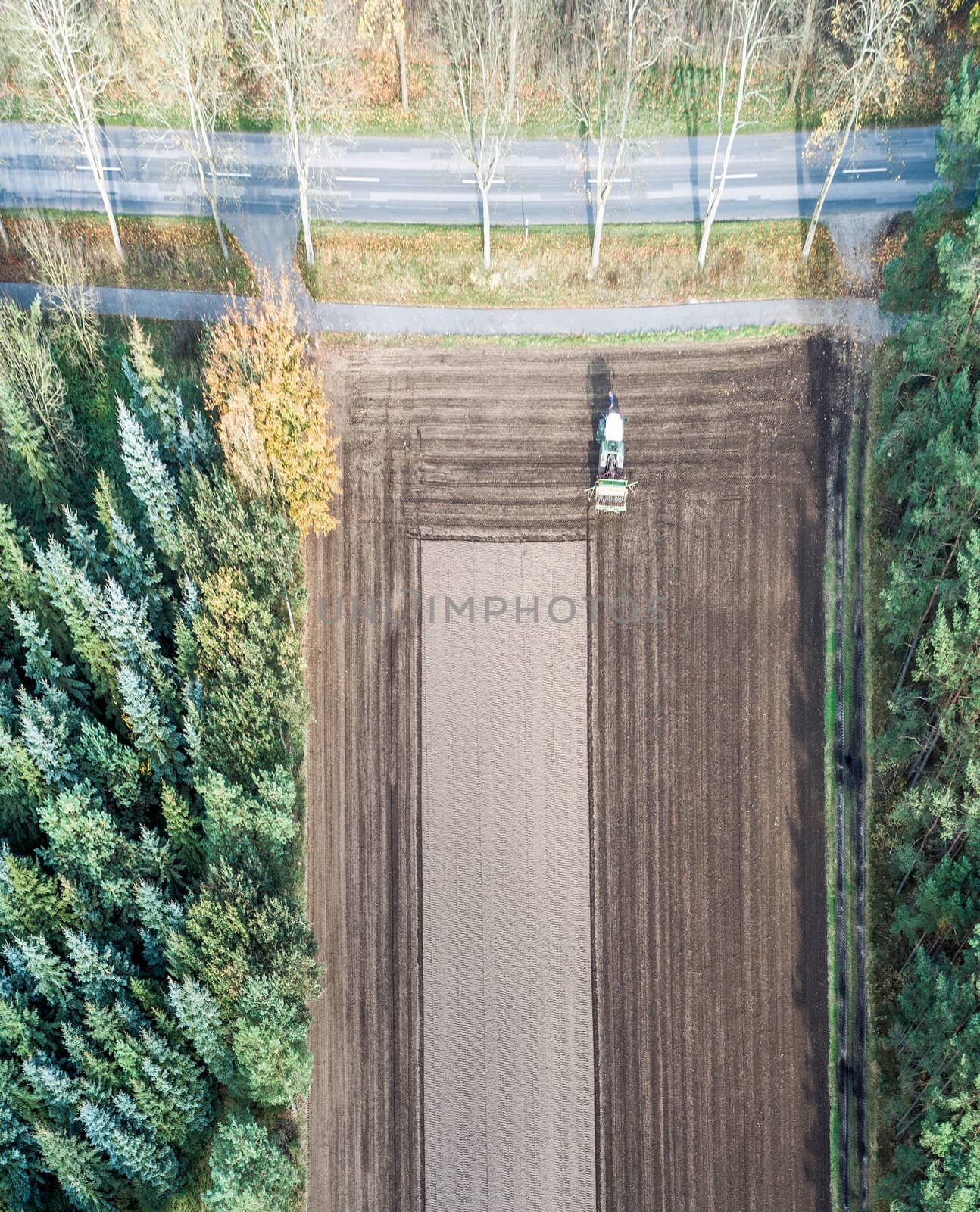 Vertically aligned aerial photograph taken with the drone of an area of arable land treated by a tractor