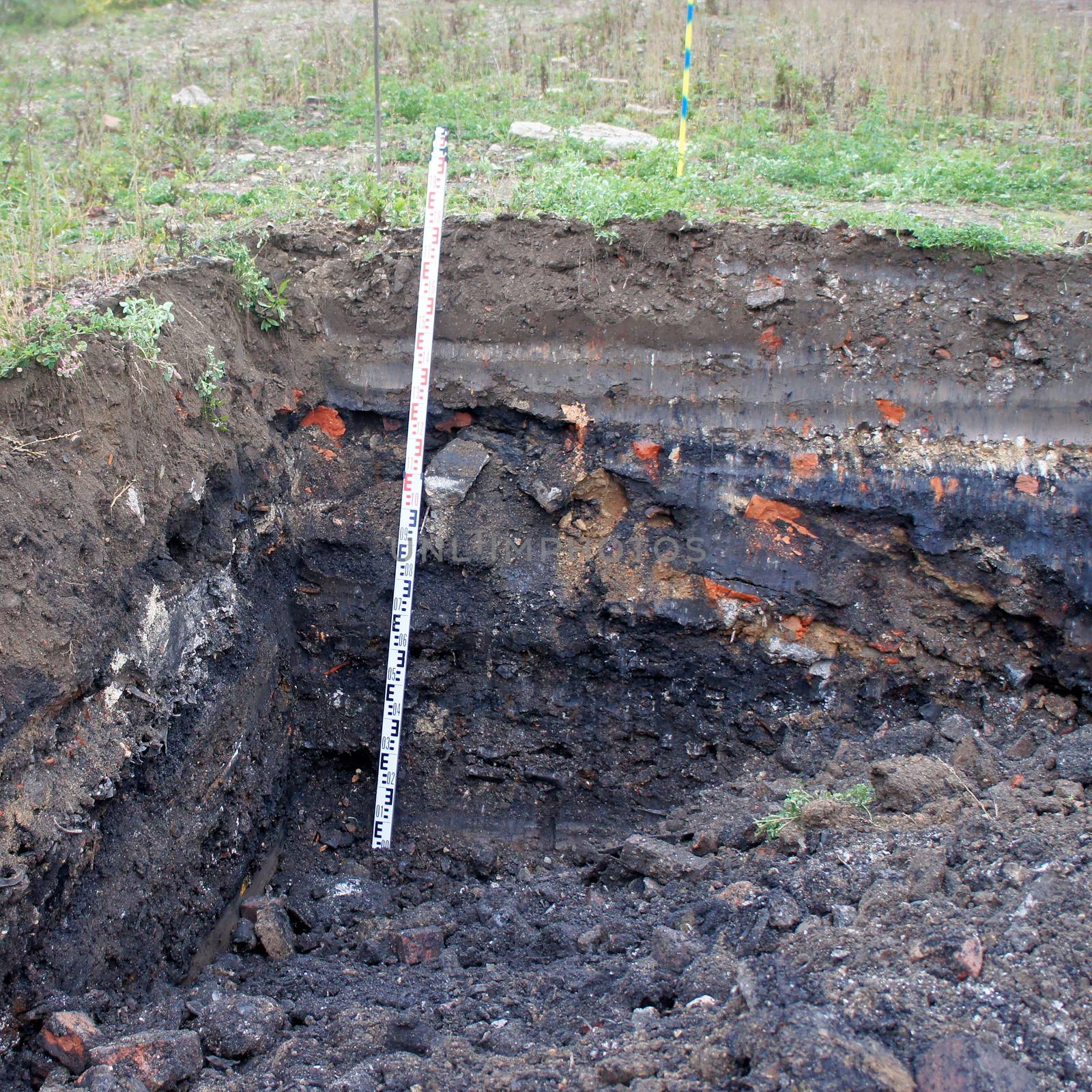 Former rubbish dump in the excavation pit, black discoloured and contaminated soil, old deposit in a construction area for residential buildings