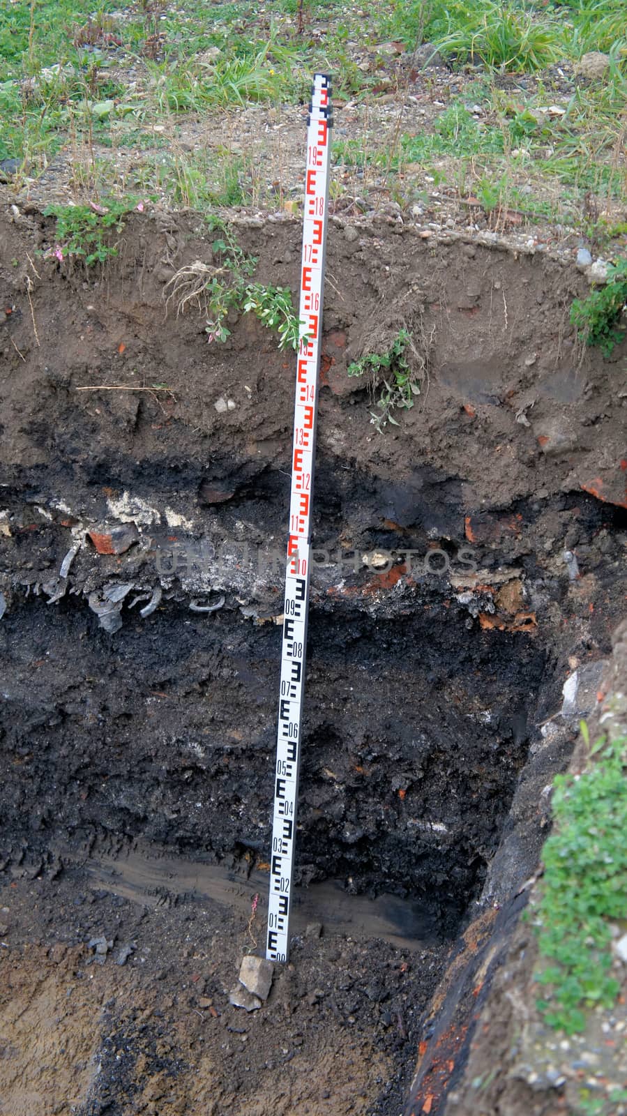 Former rubbish dump in the excavation pit, black discoloured and contaminated soil, old deposit in a construction area for residential buildings