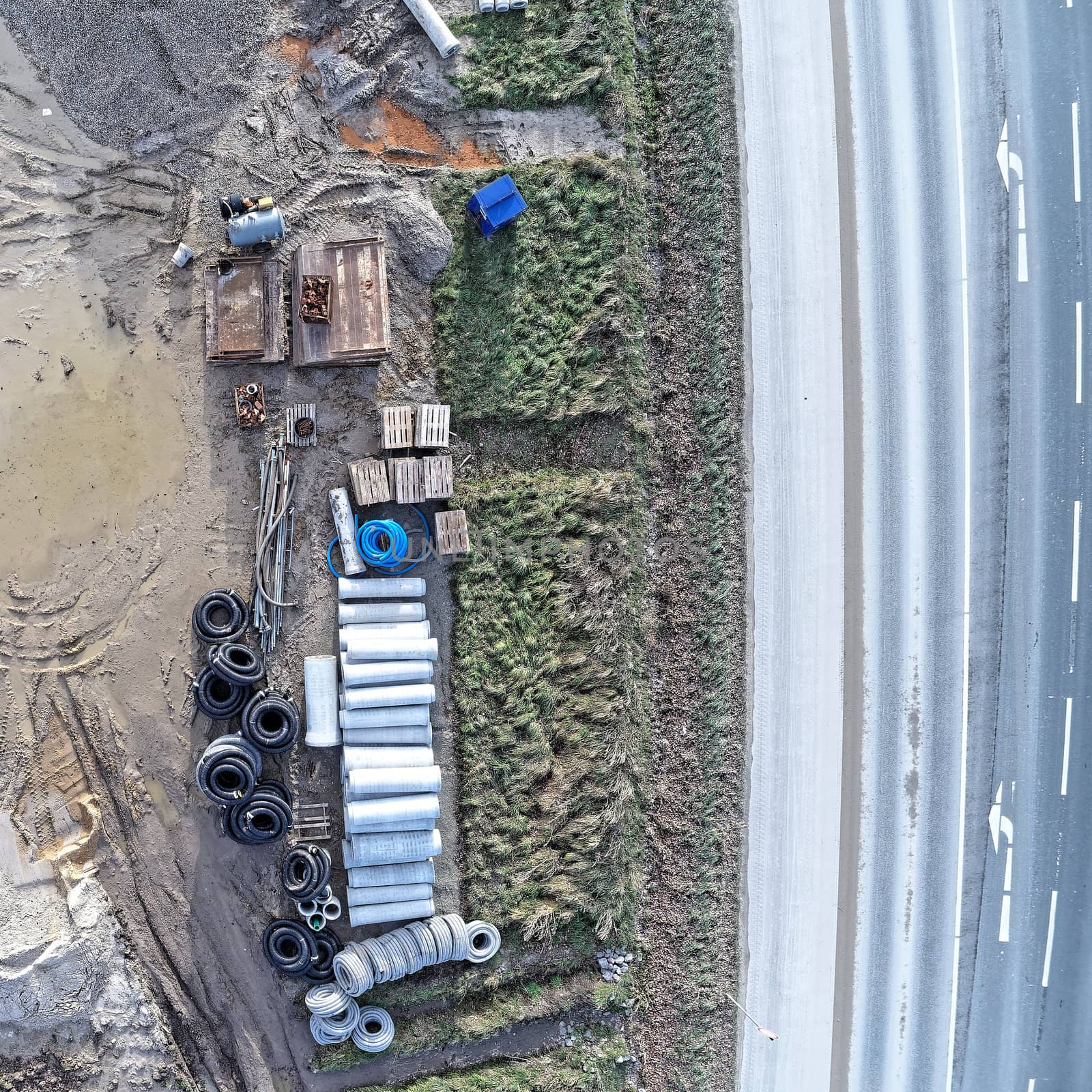 Aerial photograph of the material store for canal construction work on the construction site of a new development area, photographed with the drone