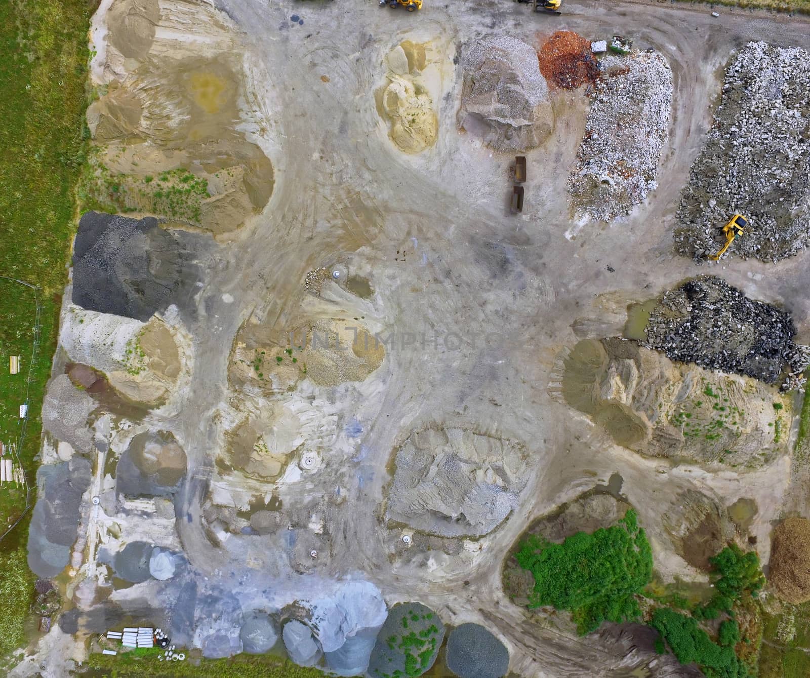 Aerial photograph of piles of rubble, sand, gravel and bricks and recycled materials in a warehouse