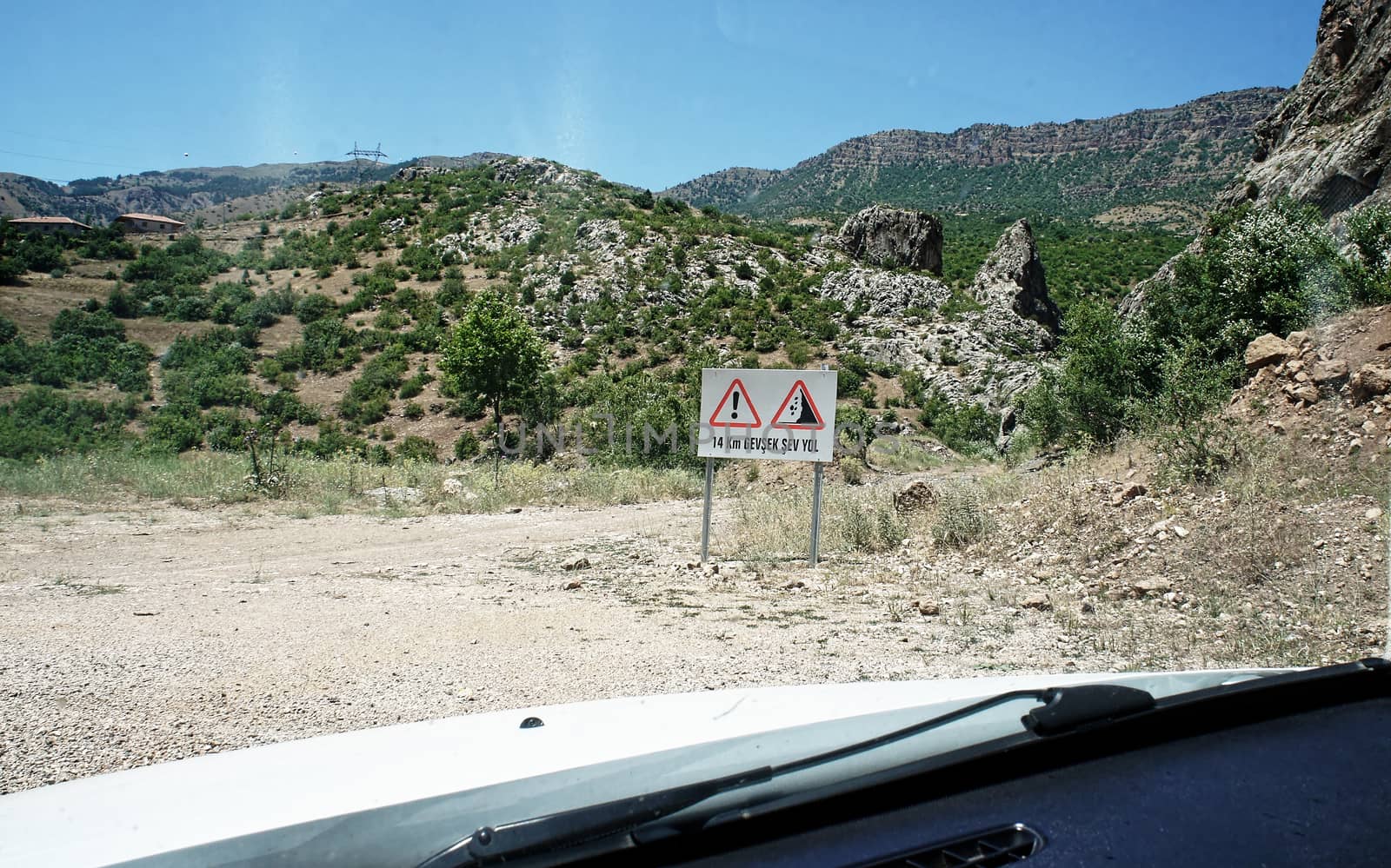 Gravel road with warning signs through the Taurus Mountains, Turkey