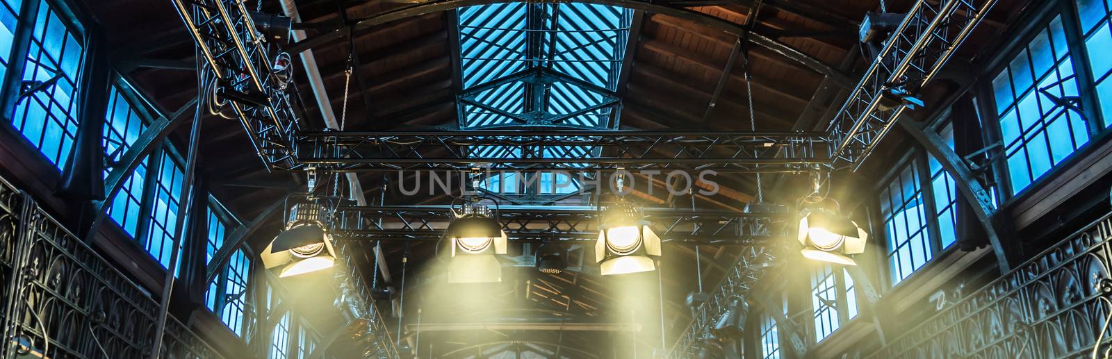 Spotlight on the ceiling of a former factory hall for lighting during a concert with rock music