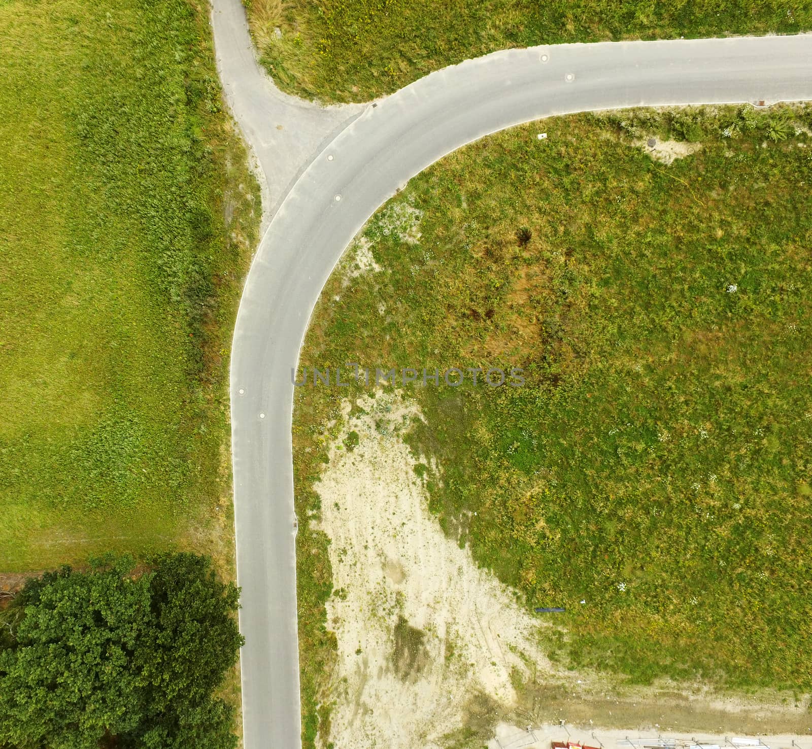 Abstract aerial photograph of a curve on a road with a branch, taken with the drone from a height of 70 meters.