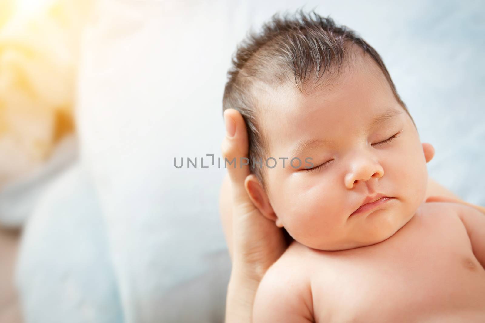 love and relationship in family. Mother holding head of her beautiful newborn daughter in hands. Loving mother hand holding cute sleeping newborn baby child close eye with relax and comfortable.