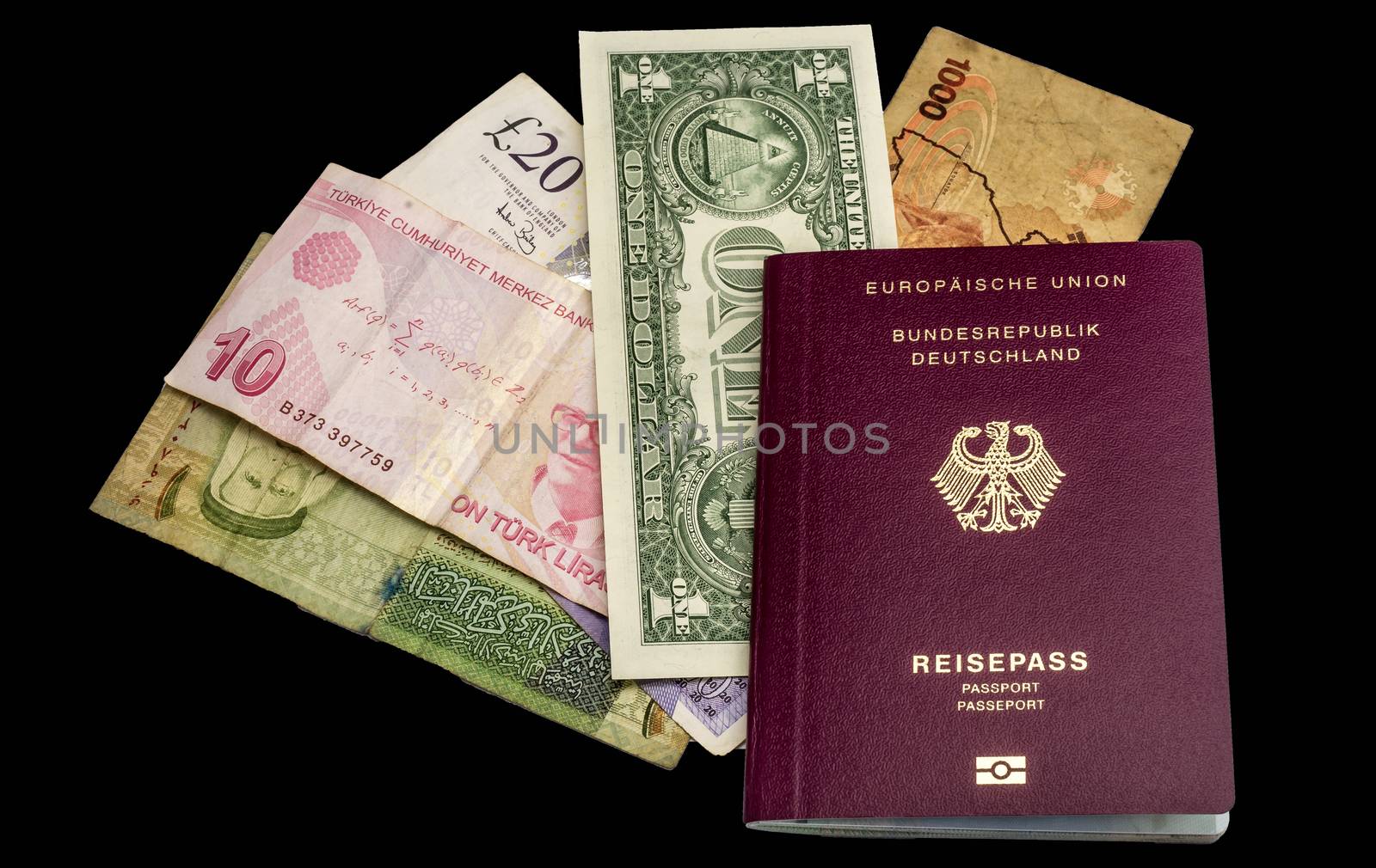 Preparing for a trip around the world with passport, banknotes from USA, Uganda, England, Turkey and Jordan, isolated against black background