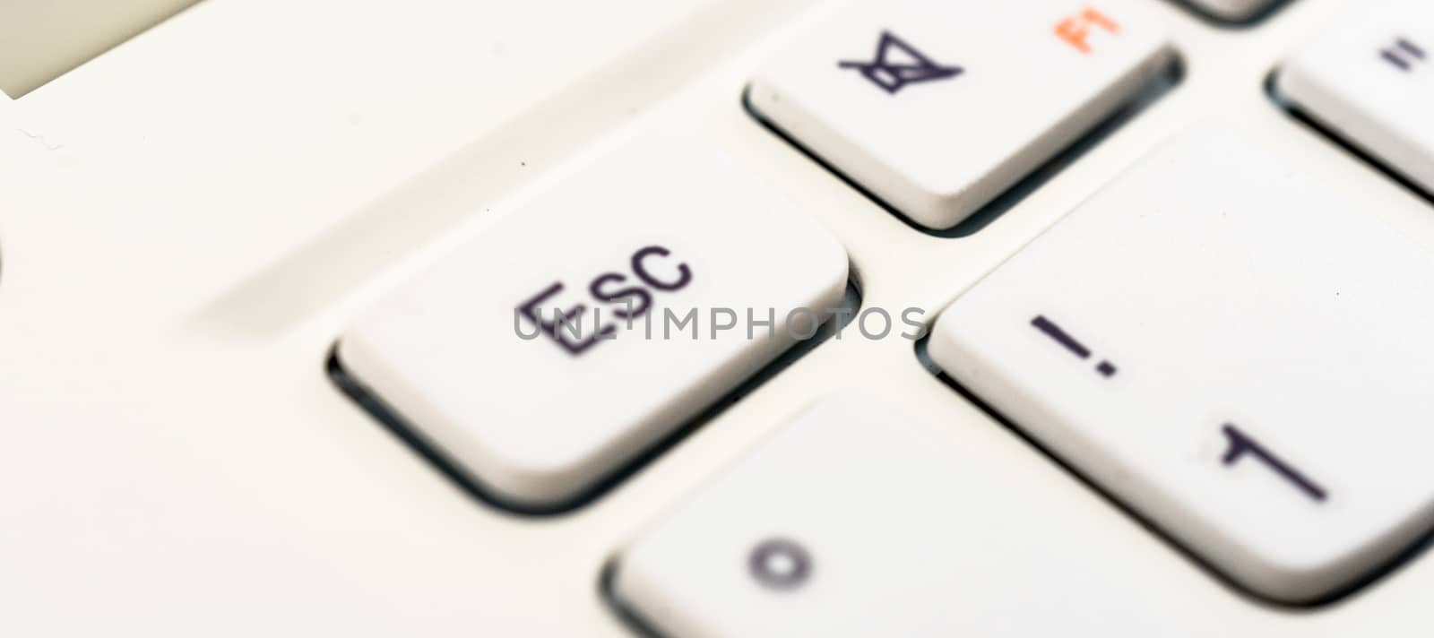 Macro recording of the escape character on a white laptop keyboard, abstract escape concept