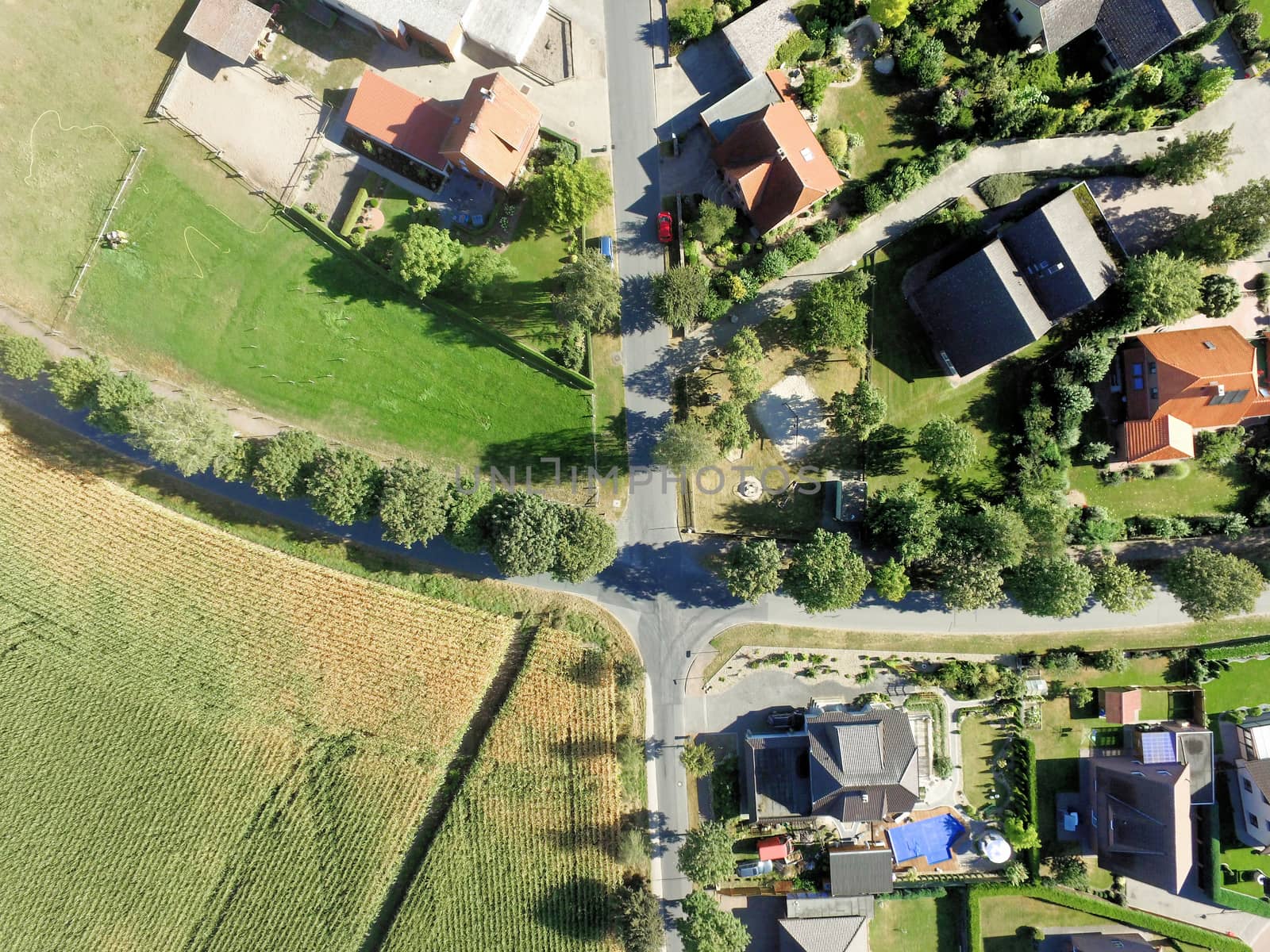 Aerial view from the edge of a village in Germany with a crossing and houses