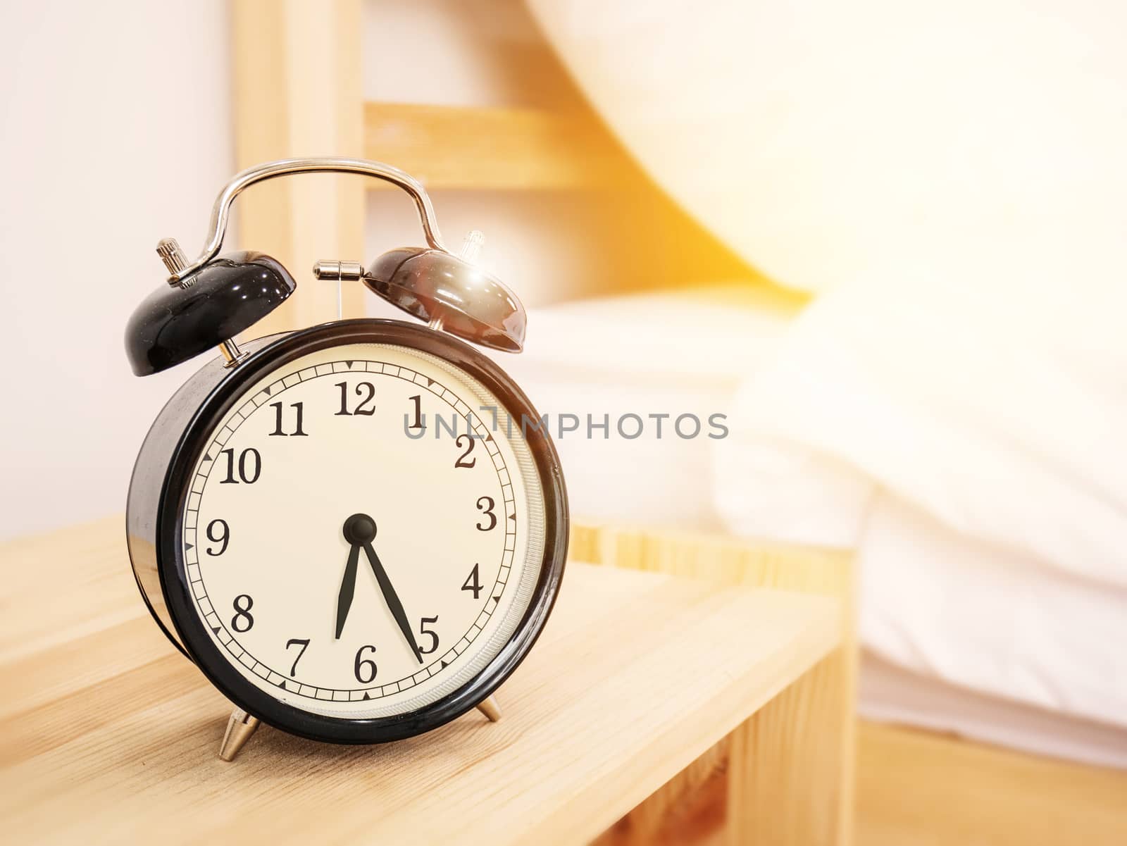 morning time background, retro alarm clock near the bed at home.