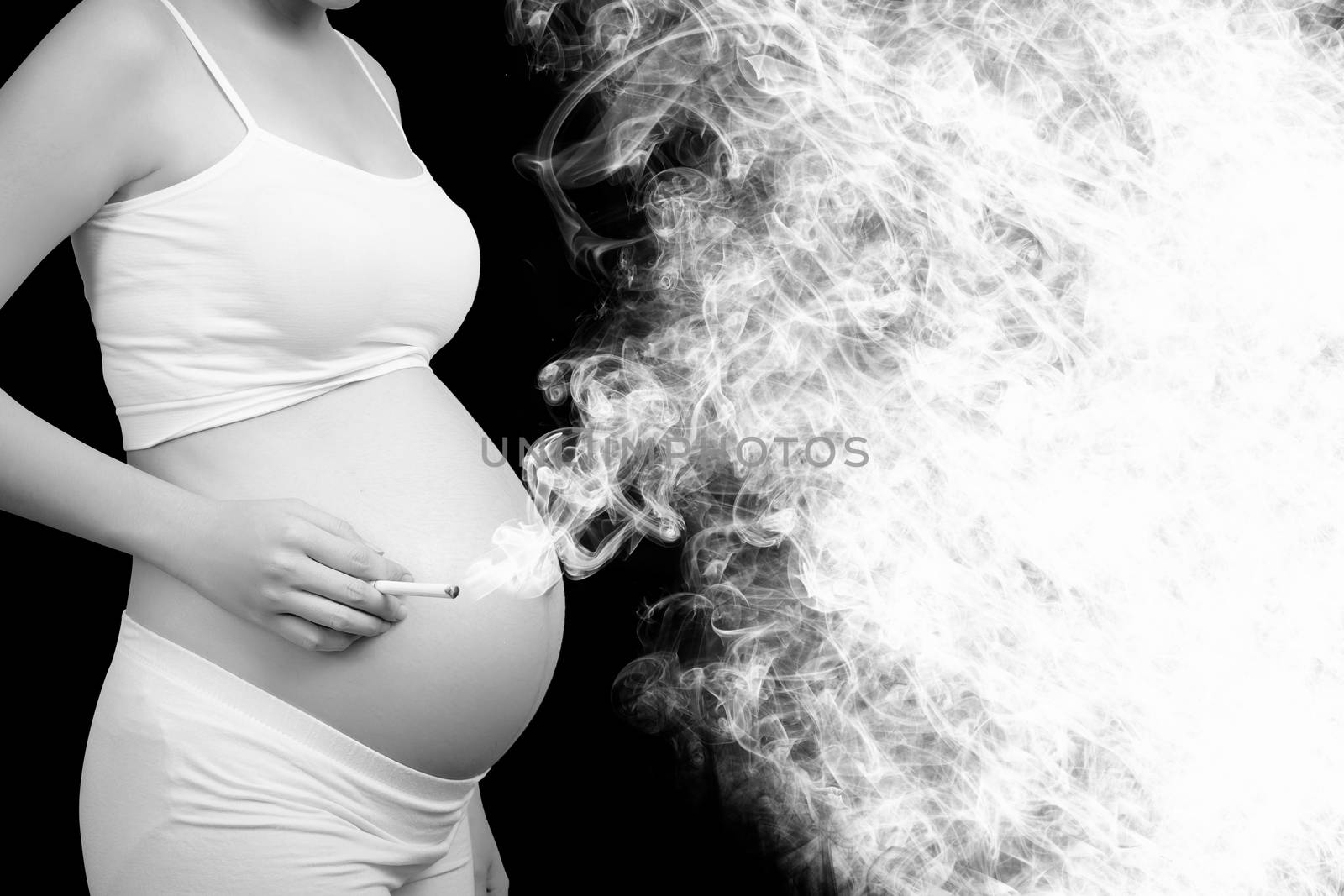 Smoking kills concept : Pregnant woman smoking cigarette cause cancer , danger and lethal health risks for parent and baby. Empty place for text. Black and white color. Stop smoking campaign