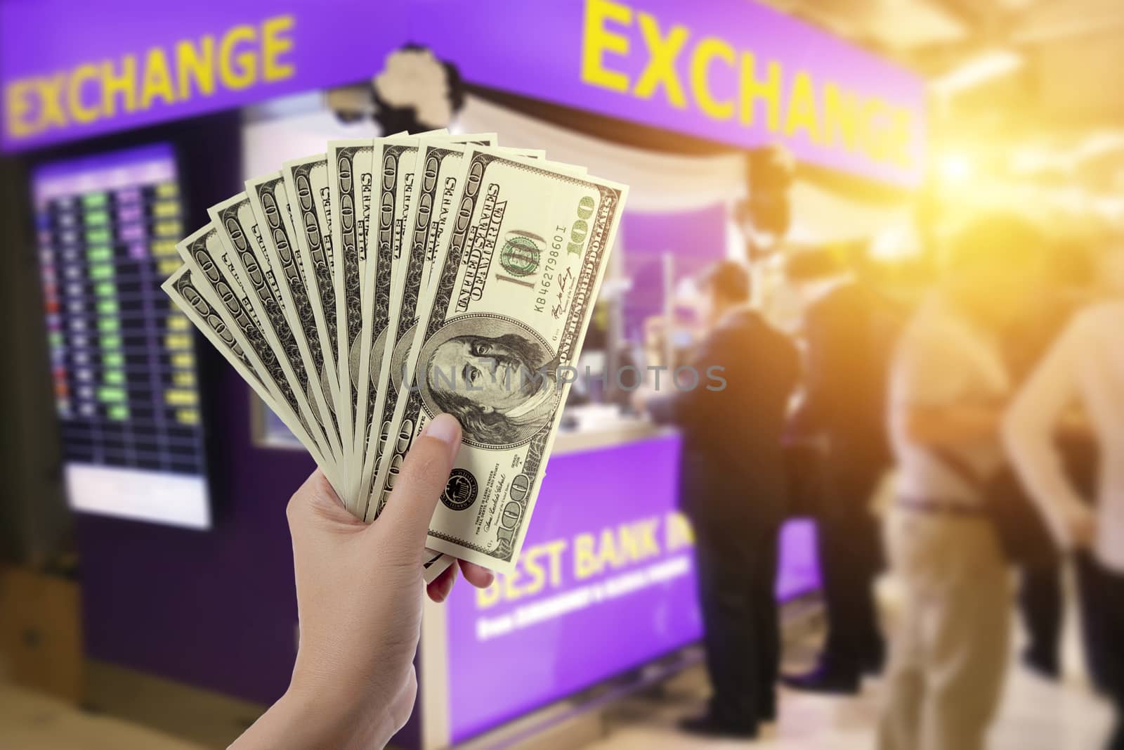 people, withdrawal, saving, finance, currency conversion and money exchange concept - hands with US dollar money with blur exchange booth background by asiandelight