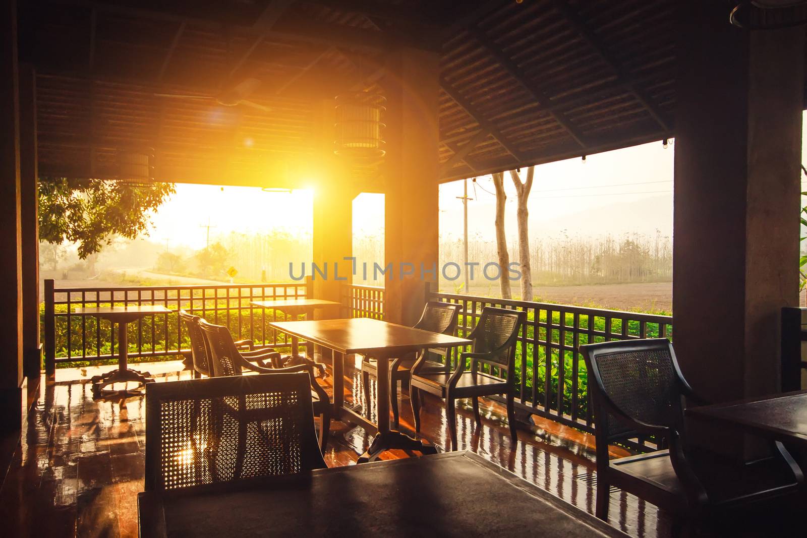 Restaurant kitchen interior concept : Empty outdoor restaurant tables at sunset light in the evening with nature view background