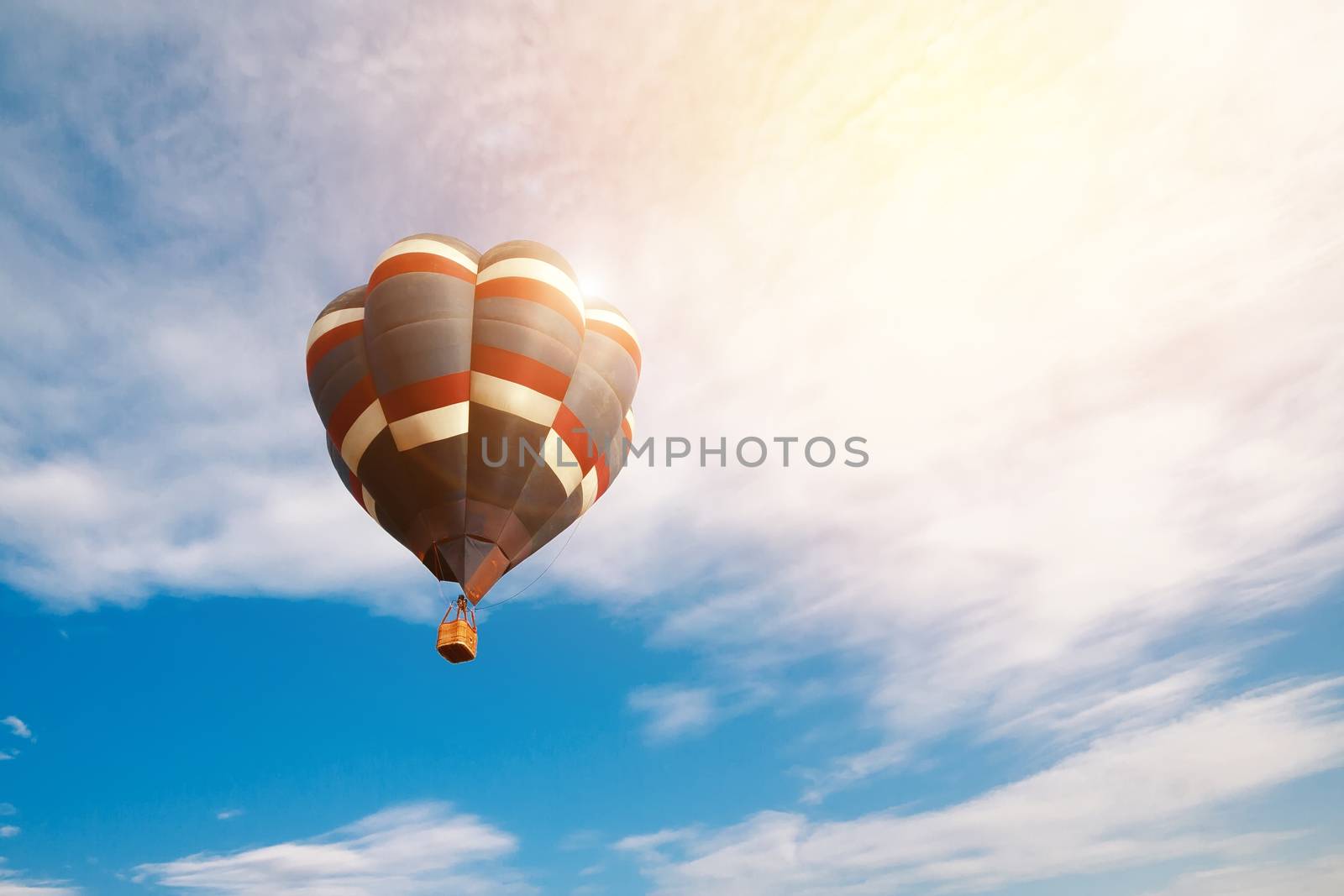 Travel and tourism concept. Colorful hot air balloon flying at sunrise with cloudy blue sky background by asiandelight