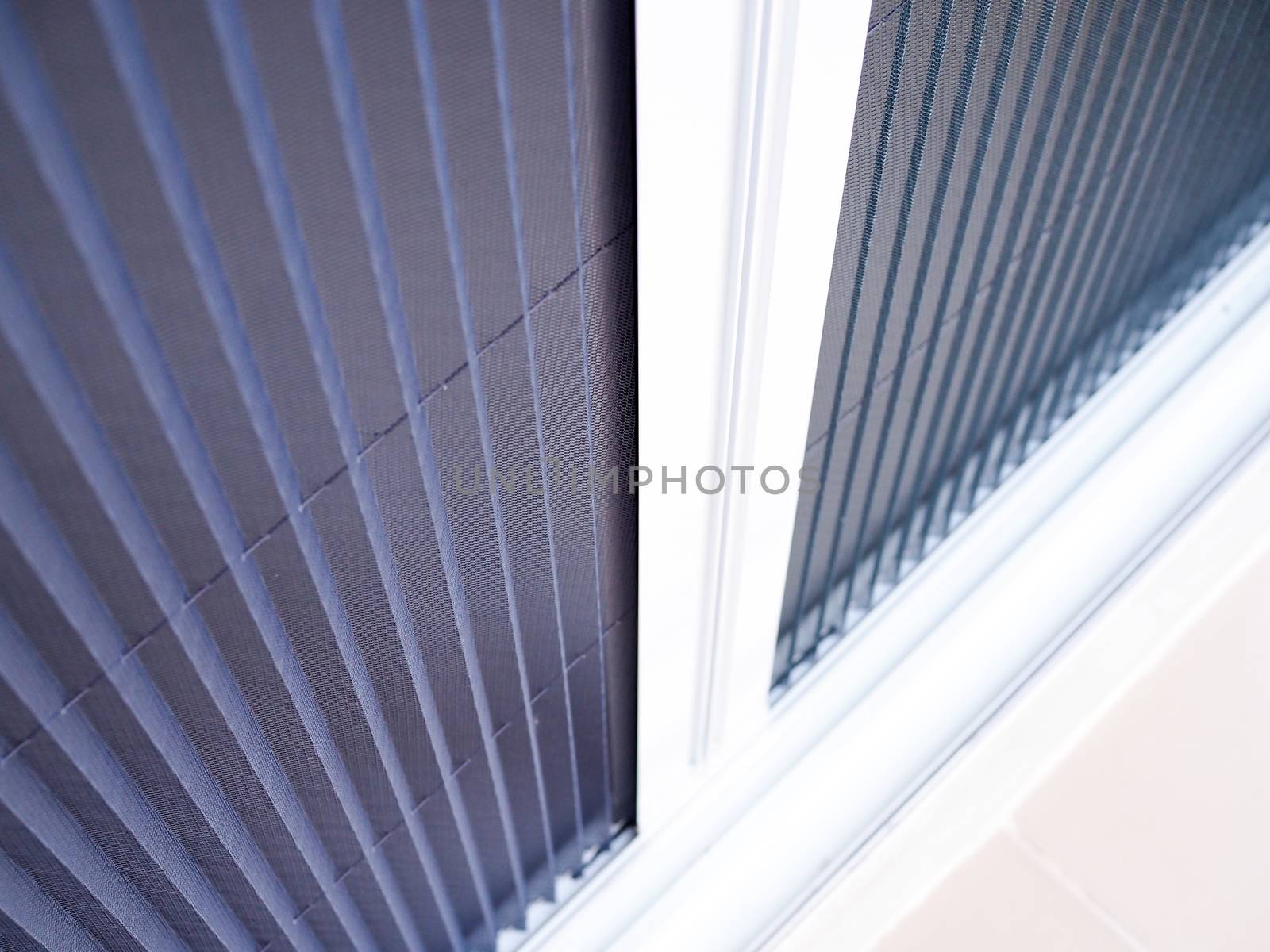 selective focus on white frame door with mosquito net wire screen.