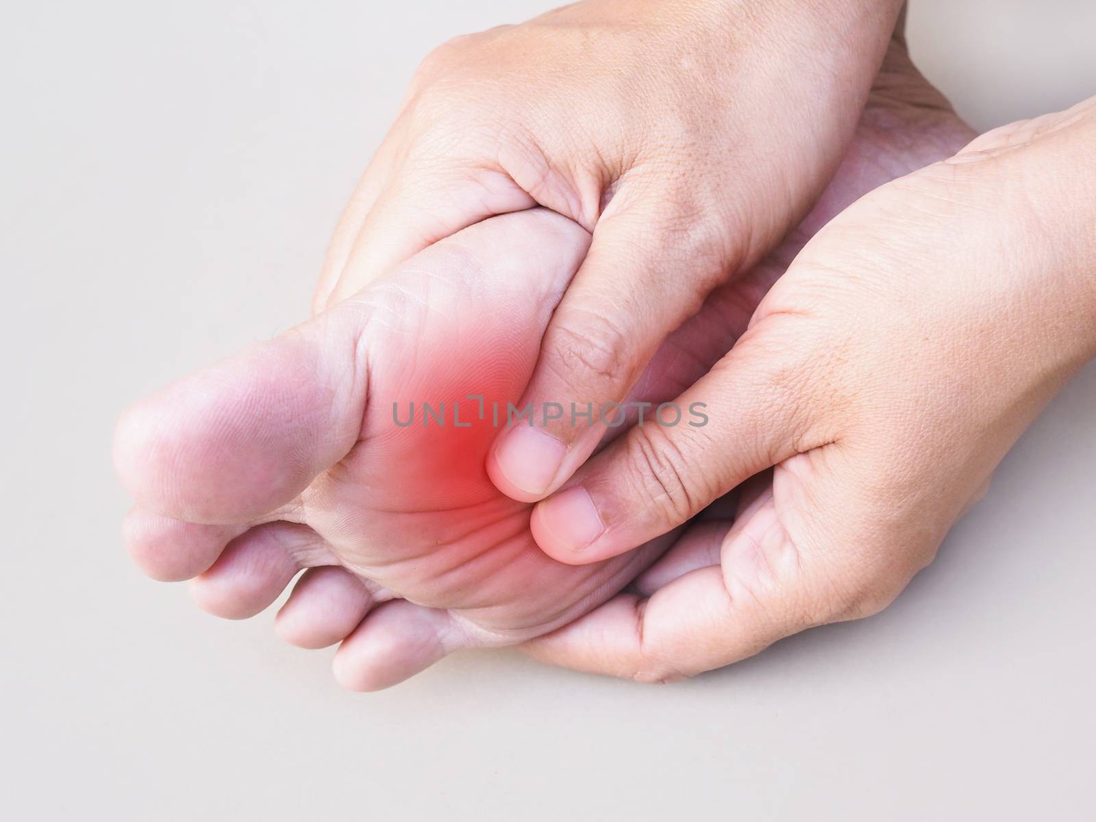 Young asian woman suffering pain in ankle, heel pain and soles of feet using hand to massage body to relieve pain, medical symptom and healthcare concept.