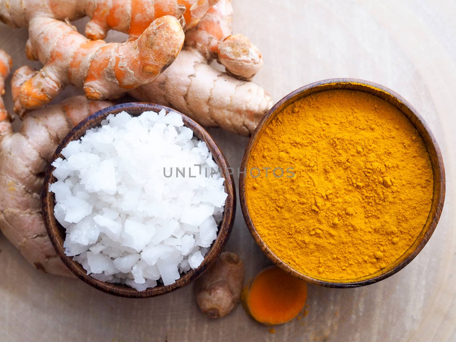 Top view of wooden bowl with turmeric powder and sea salt. by kittima05